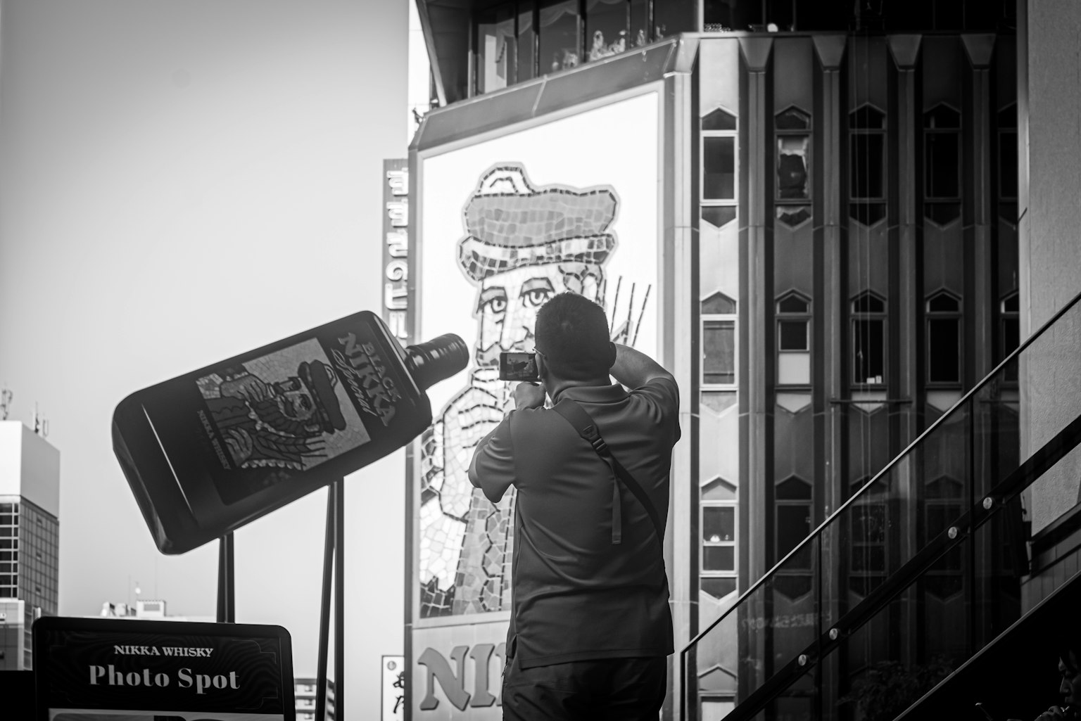 A person taking a photo of a large mural on a building