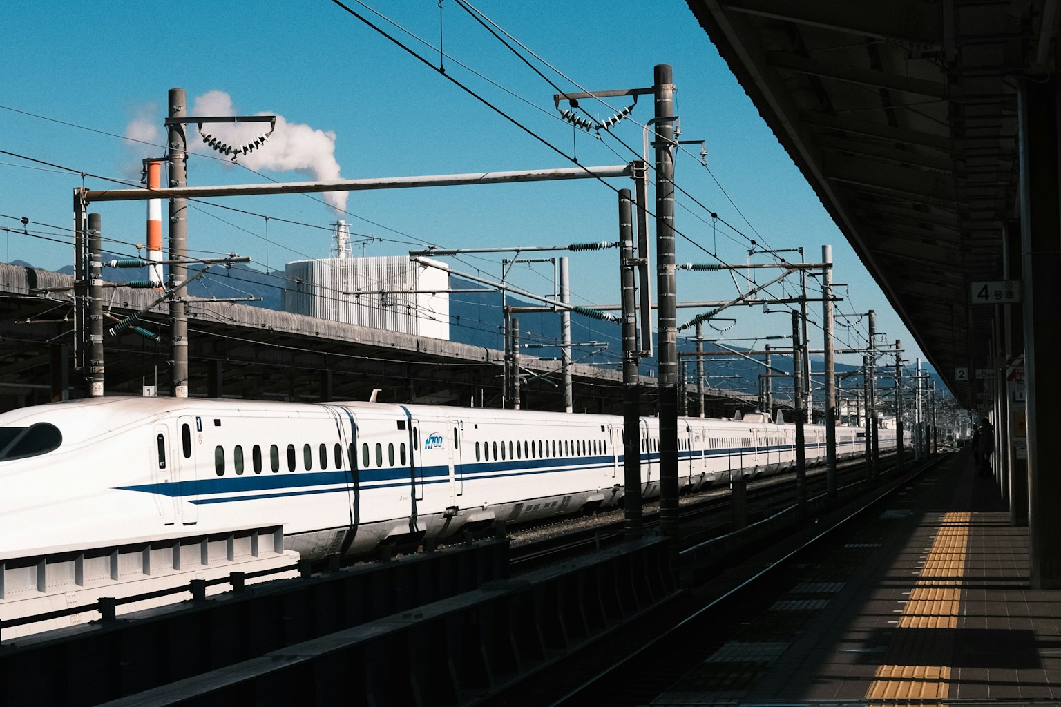 新幹線在車站停靠，背景是藍天