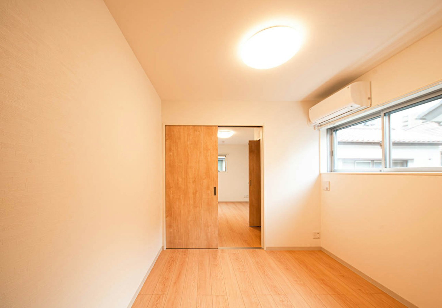 Helle Zimmer mit einer Holztür und einem Fenster in einfacher Dekoration