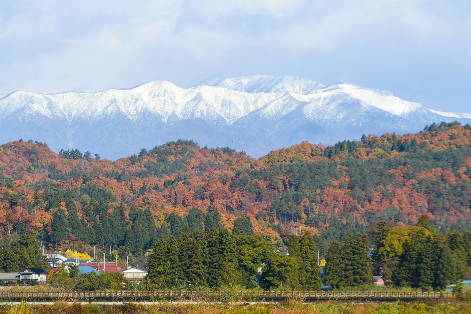 Vista escénica de montañas cubiertas de nieve con follaje otoñal colorido