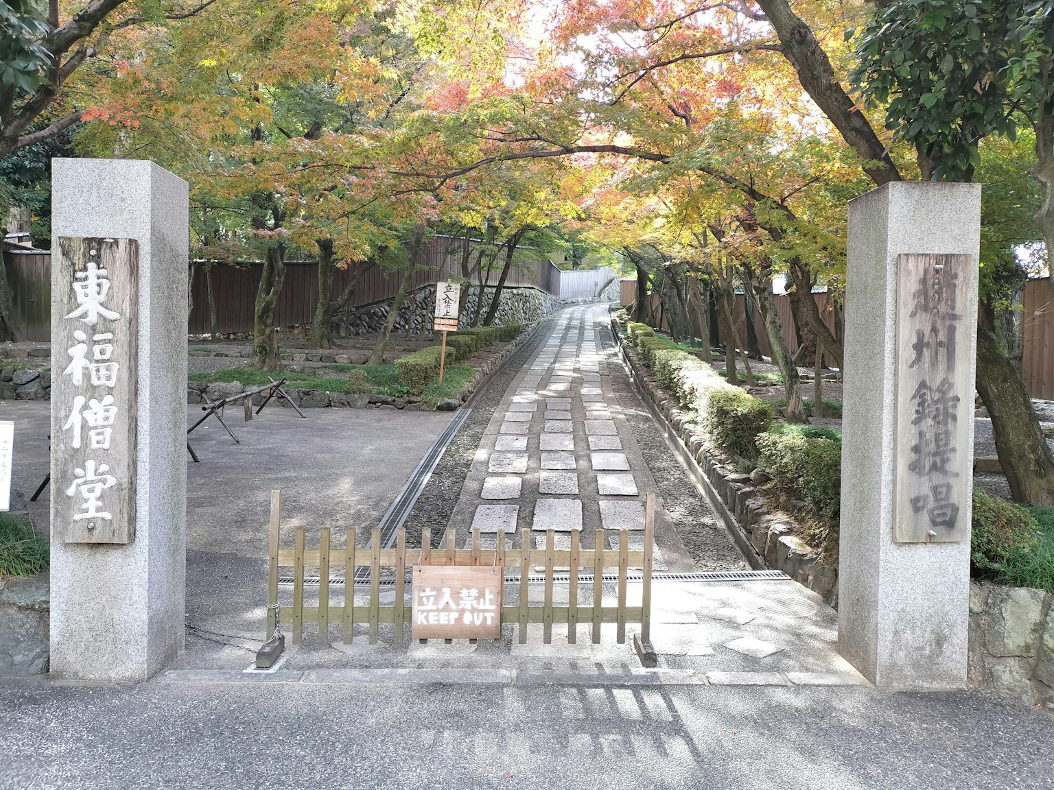 Porta di pietra all'ingresso di un sentiero circondato da foglie autunnali