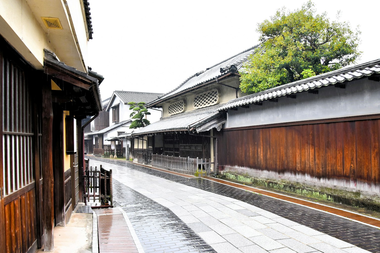 安靜的街道場景，有傳統木建築和雨水