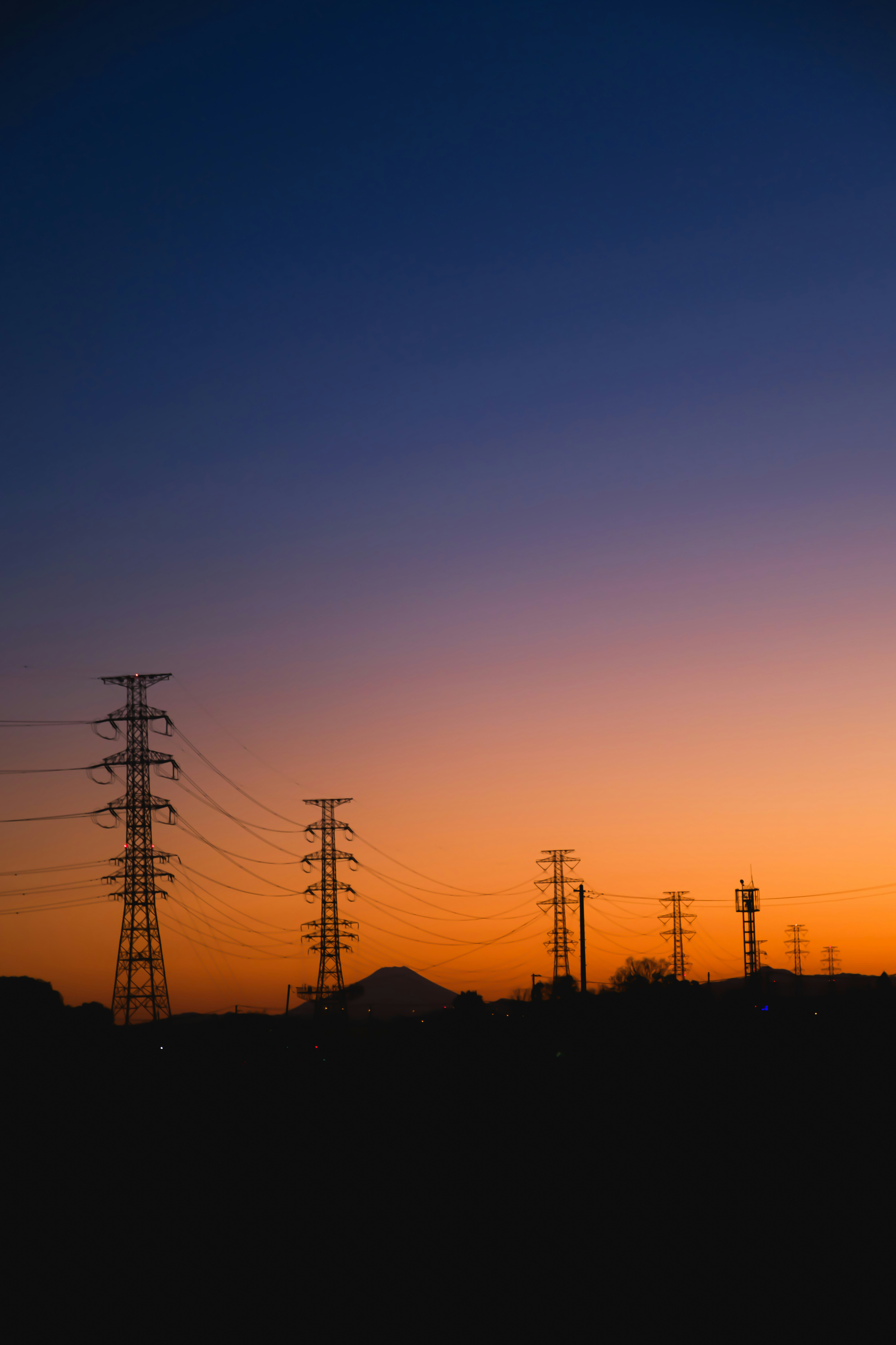 cielo al tramonto con sagome di tralicci elettrici