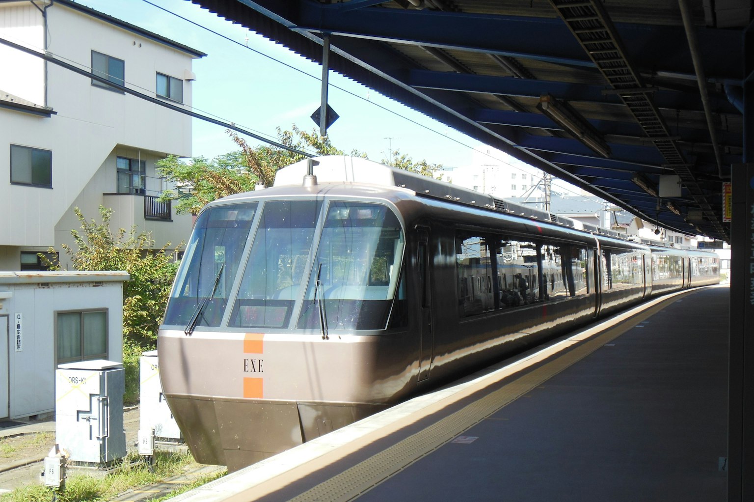 Moderner Zug an einer Station mit umliegenden Gebäuden