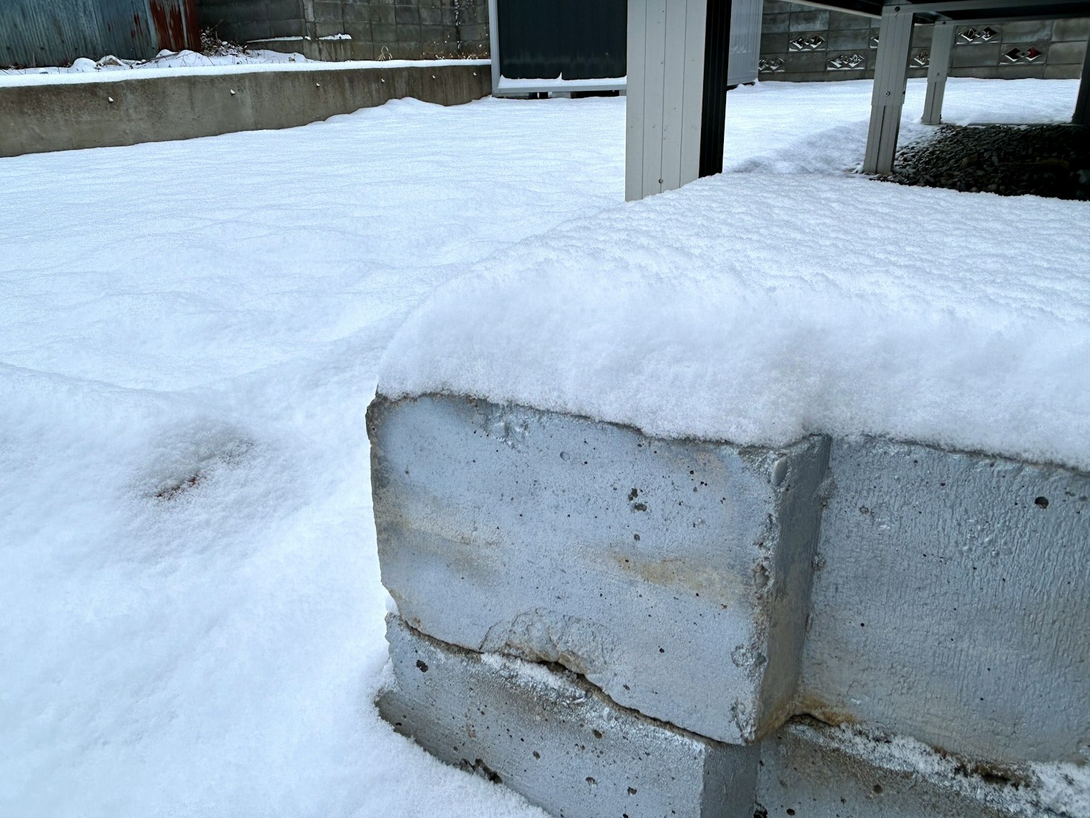 Concrete block covered in snow with surrounding snowy landscape