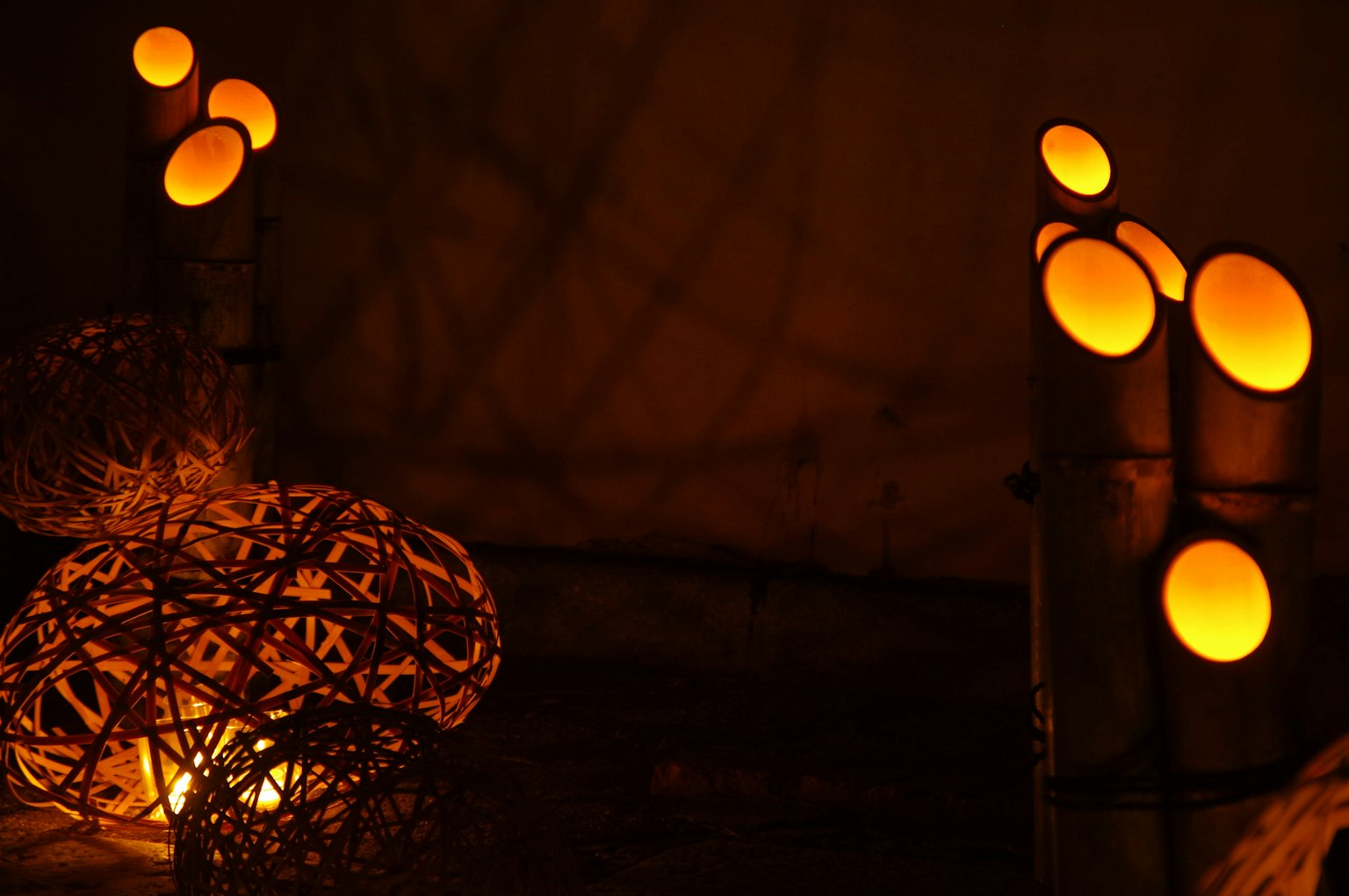 Lampes en bambou émettant une lumière orange chaleureuse avec des éléments artistiques