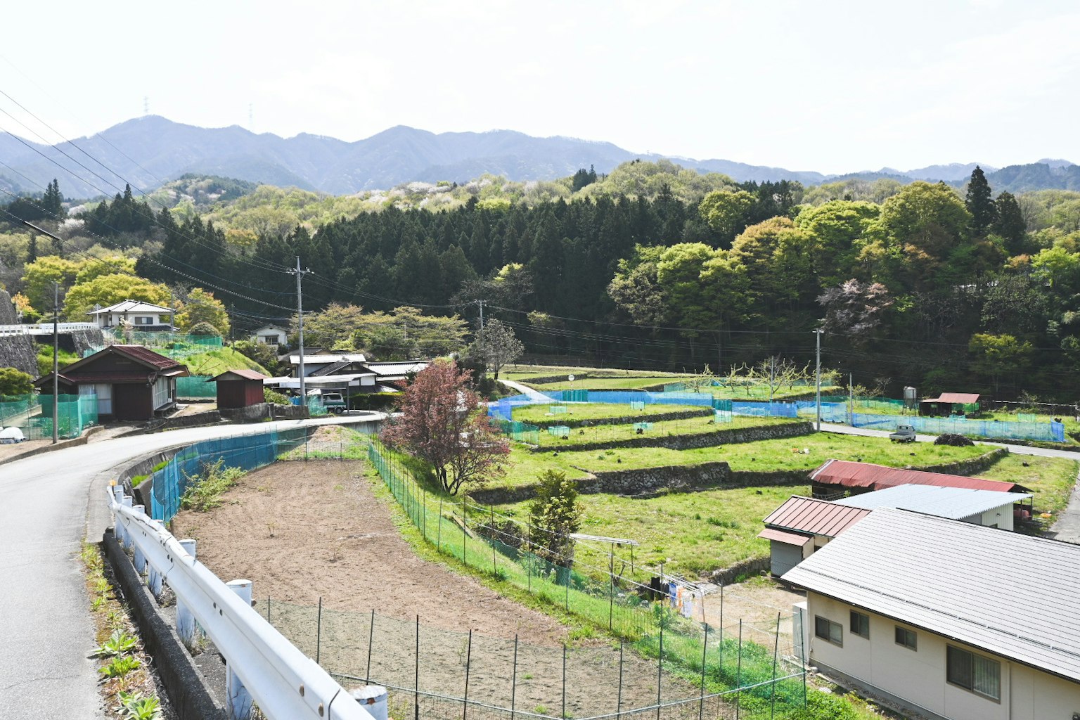 Rural landscape surrounded by mountains with green fields