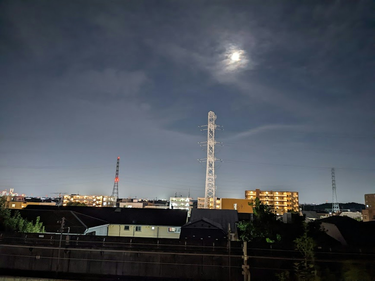 夜間城市風景，明亮的月亮和高通信塔