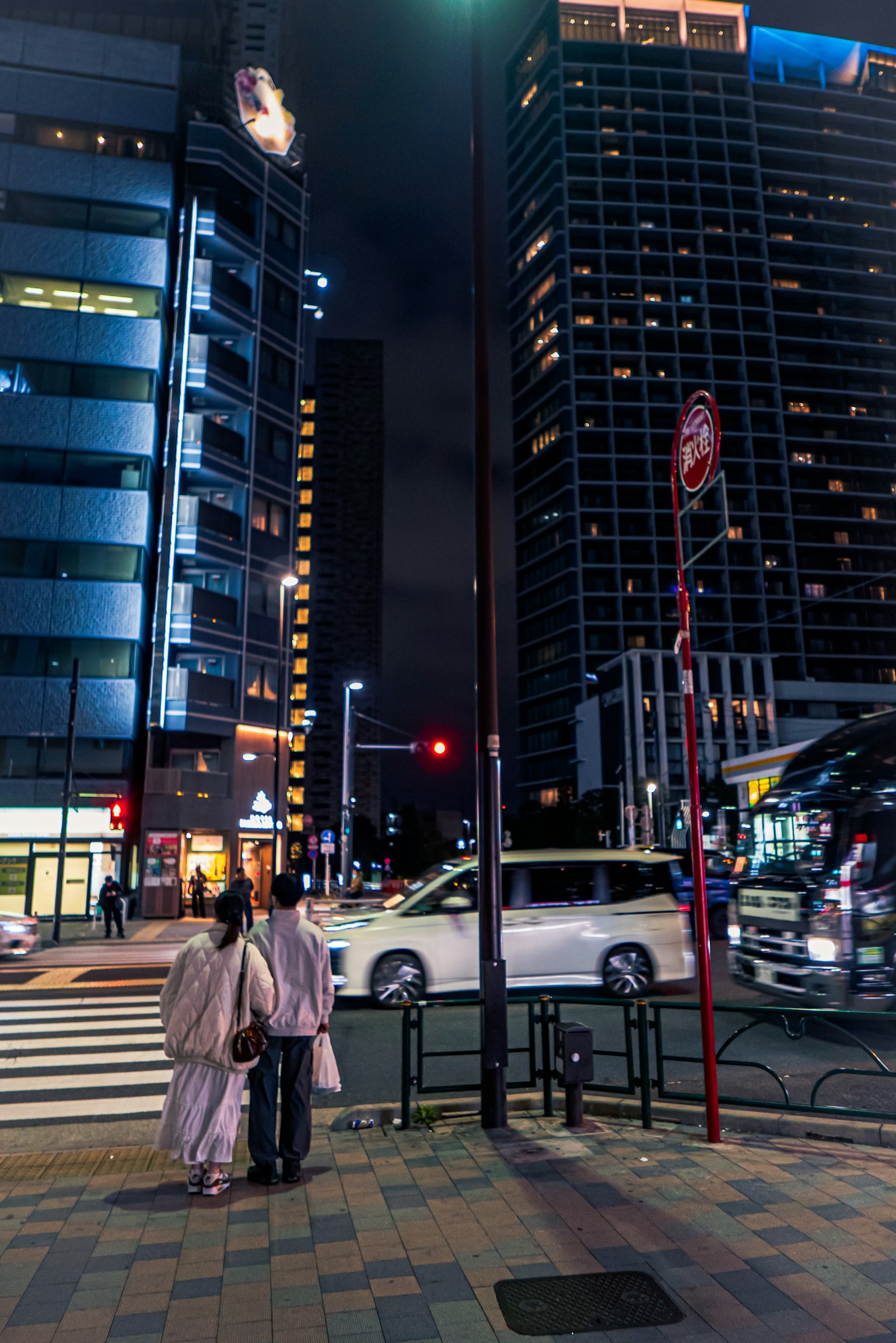 Night cityscape with people crossing the street and skyscrapers