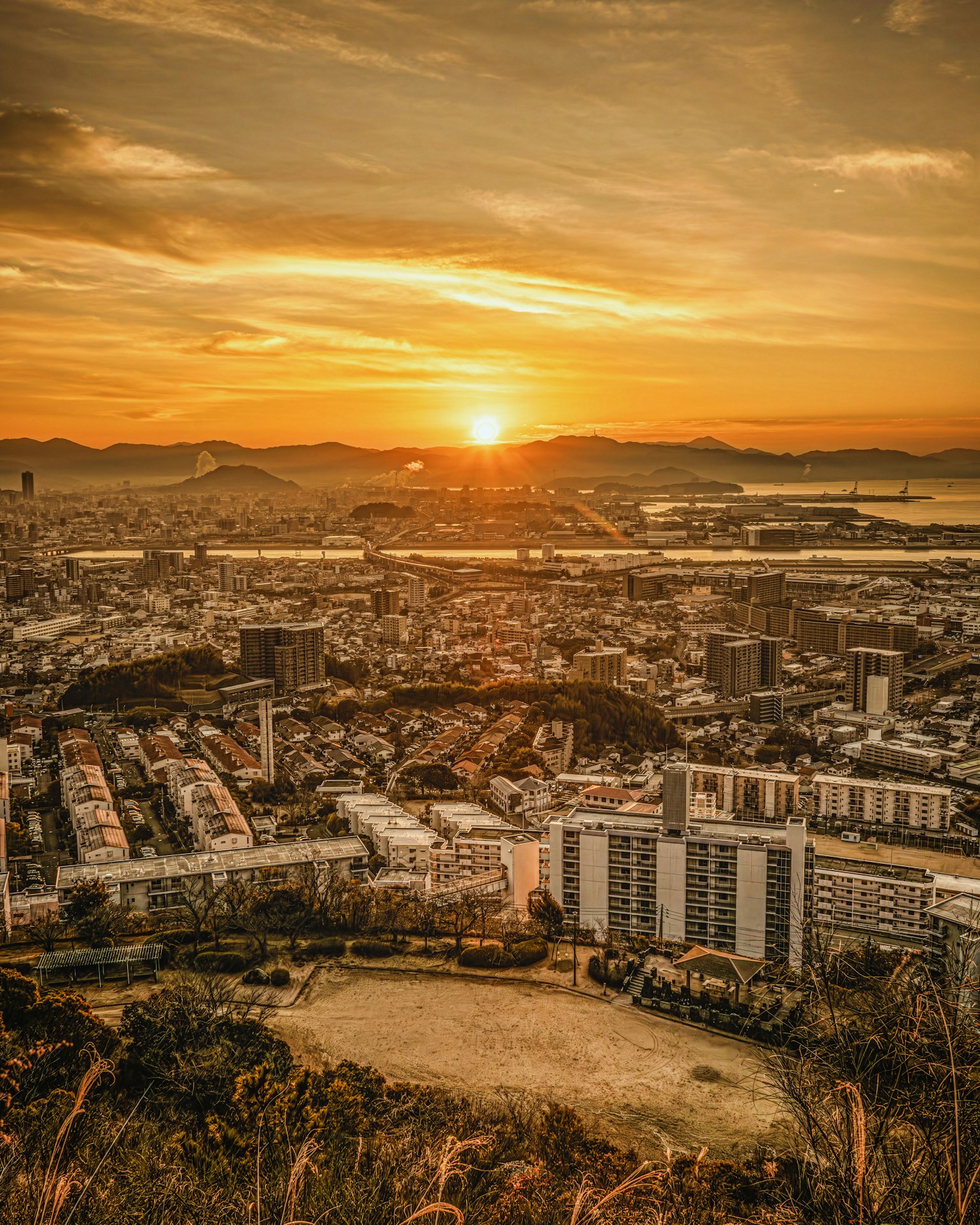 Stadtlandschaft bei Sonnenuntergang mit Blick auf die Bucht von Osaka