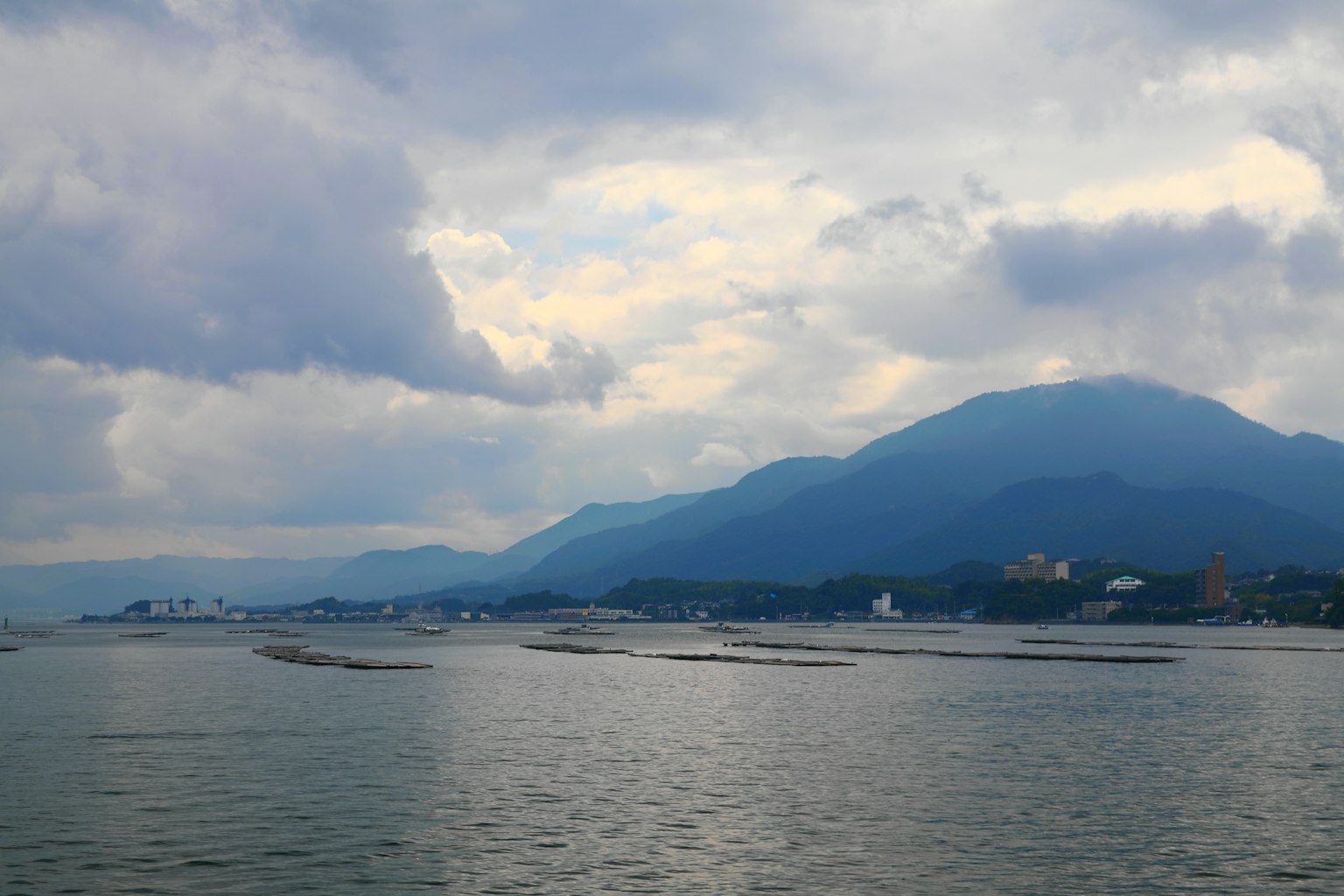Landschaft von Meer und Bergen unter einem Himmel mit Wolken