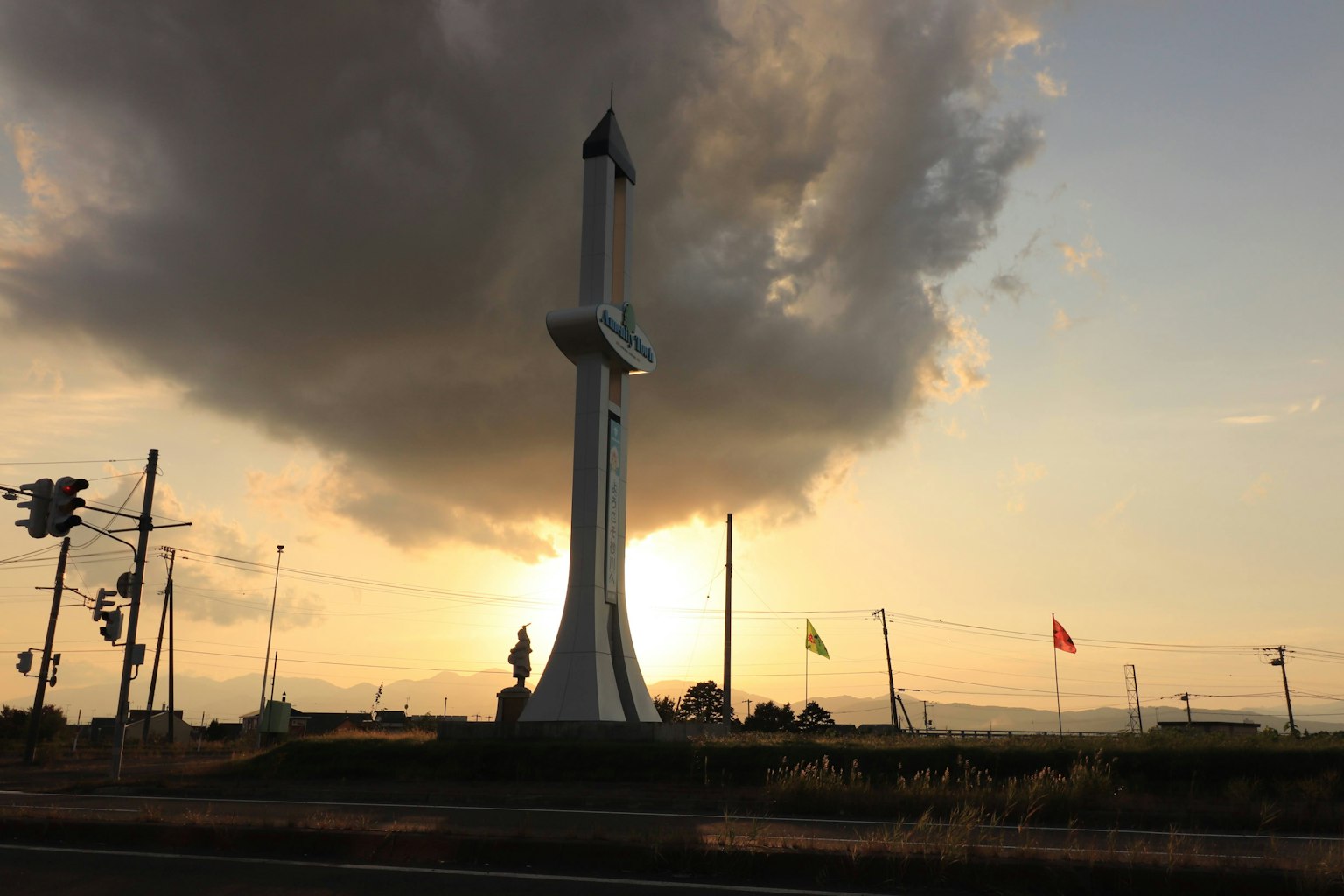 Monument silhouetté contre un coucher de soleil avec des nuages dramatiques