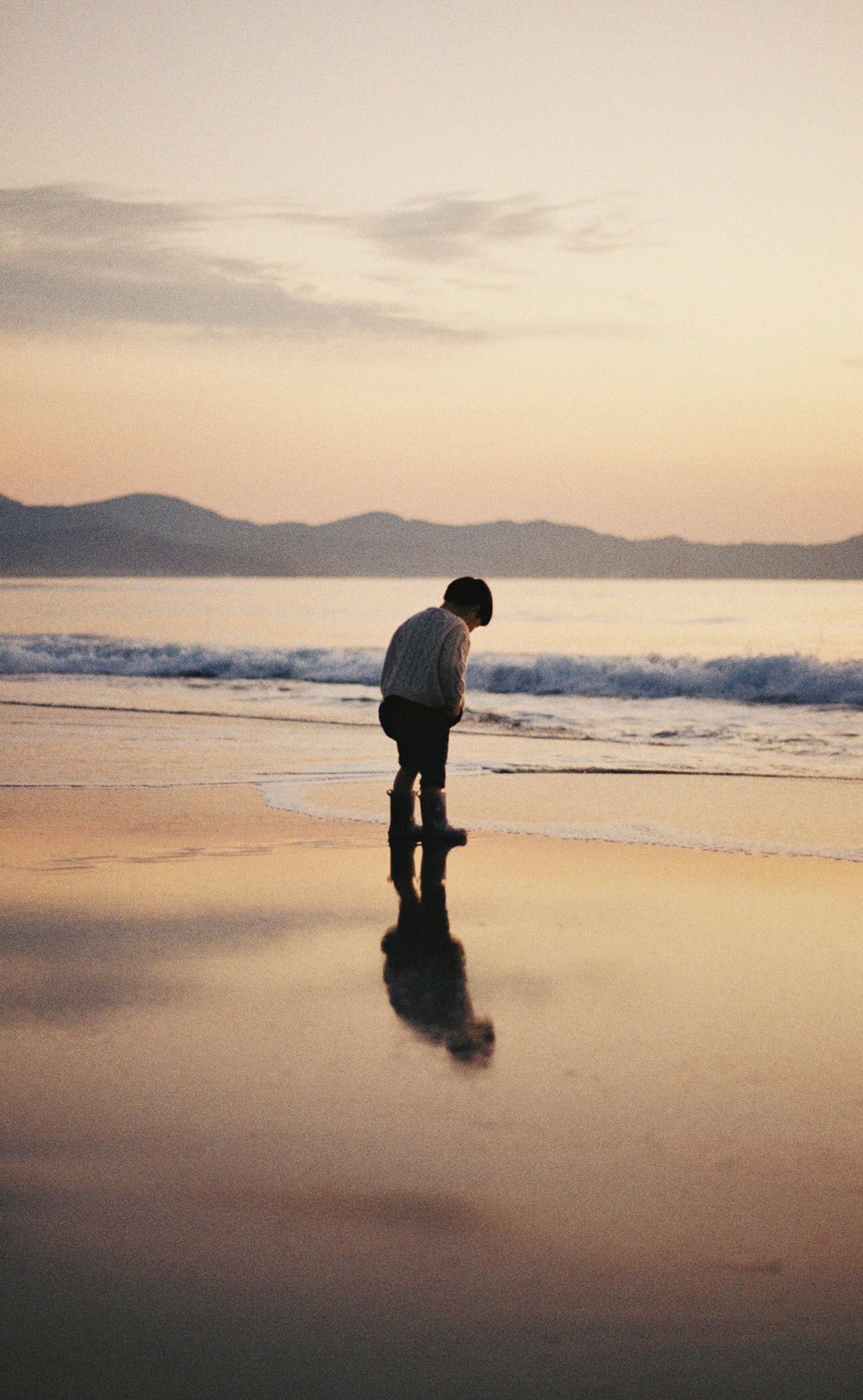 Silueta de un niño jugando en la playa al atardecer
