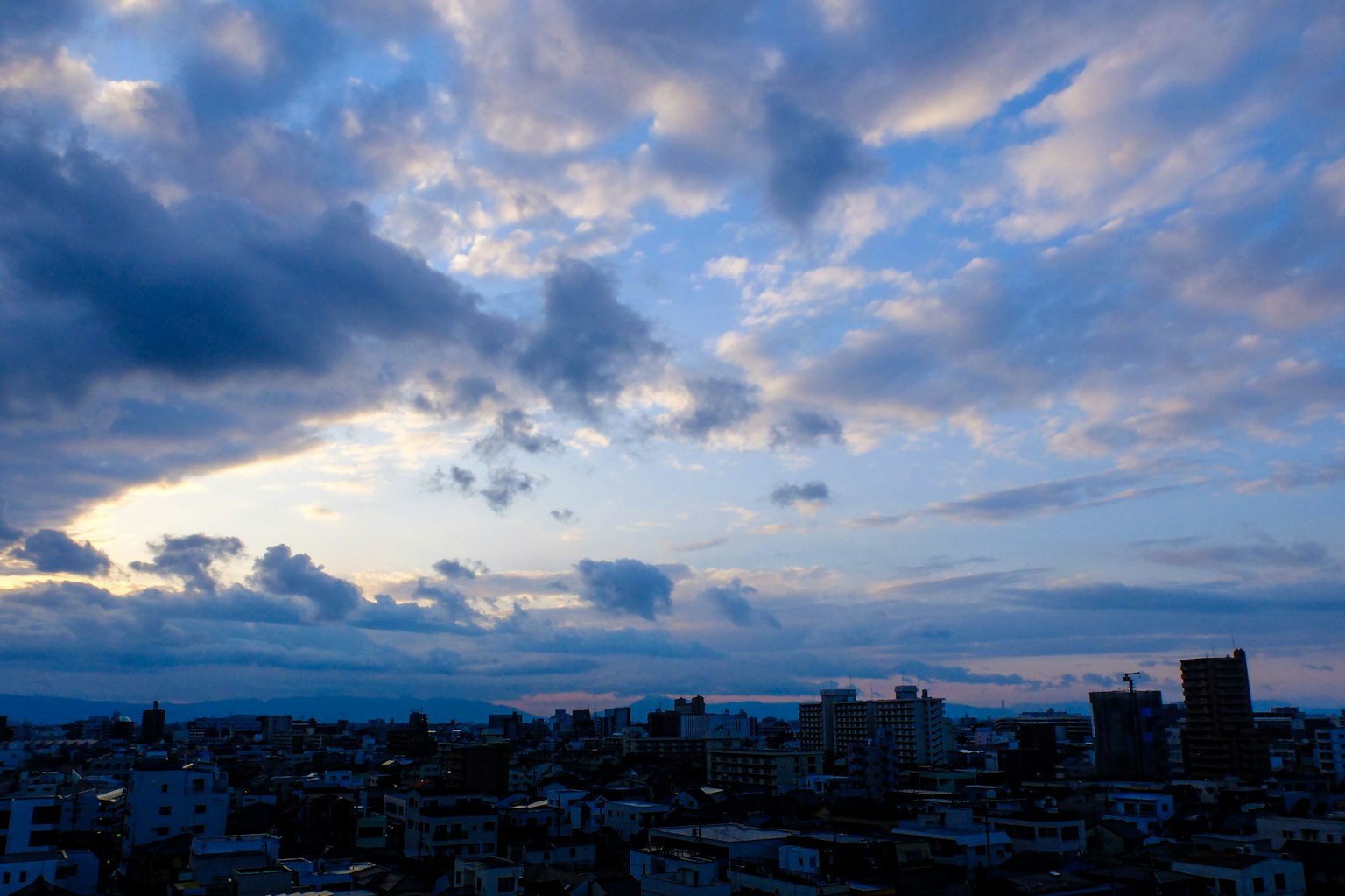 Horizonte urbano bajo un cielo azul con nubes dispersas
