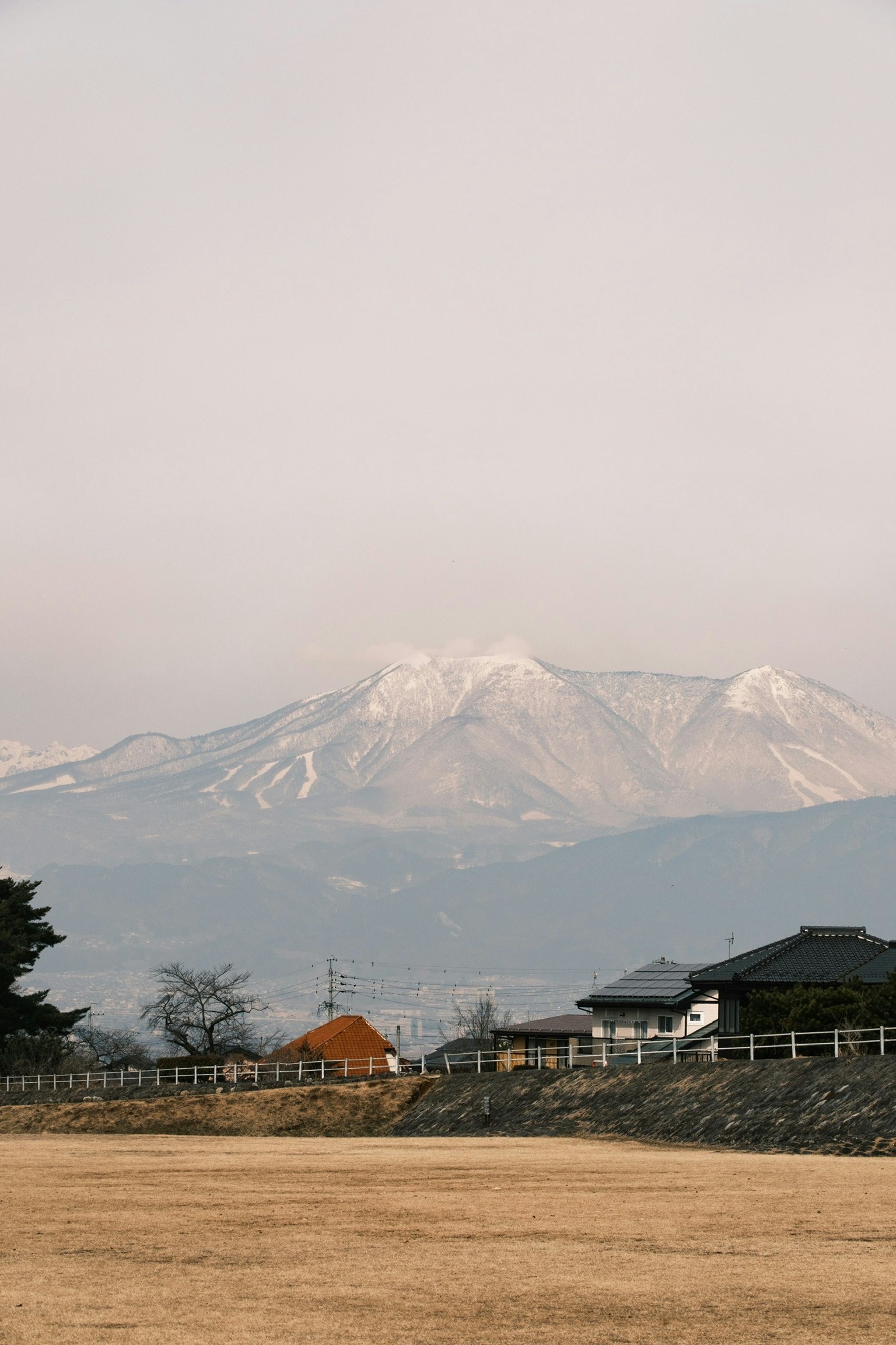 눈 덮인 산이 있는 농촌 풍경