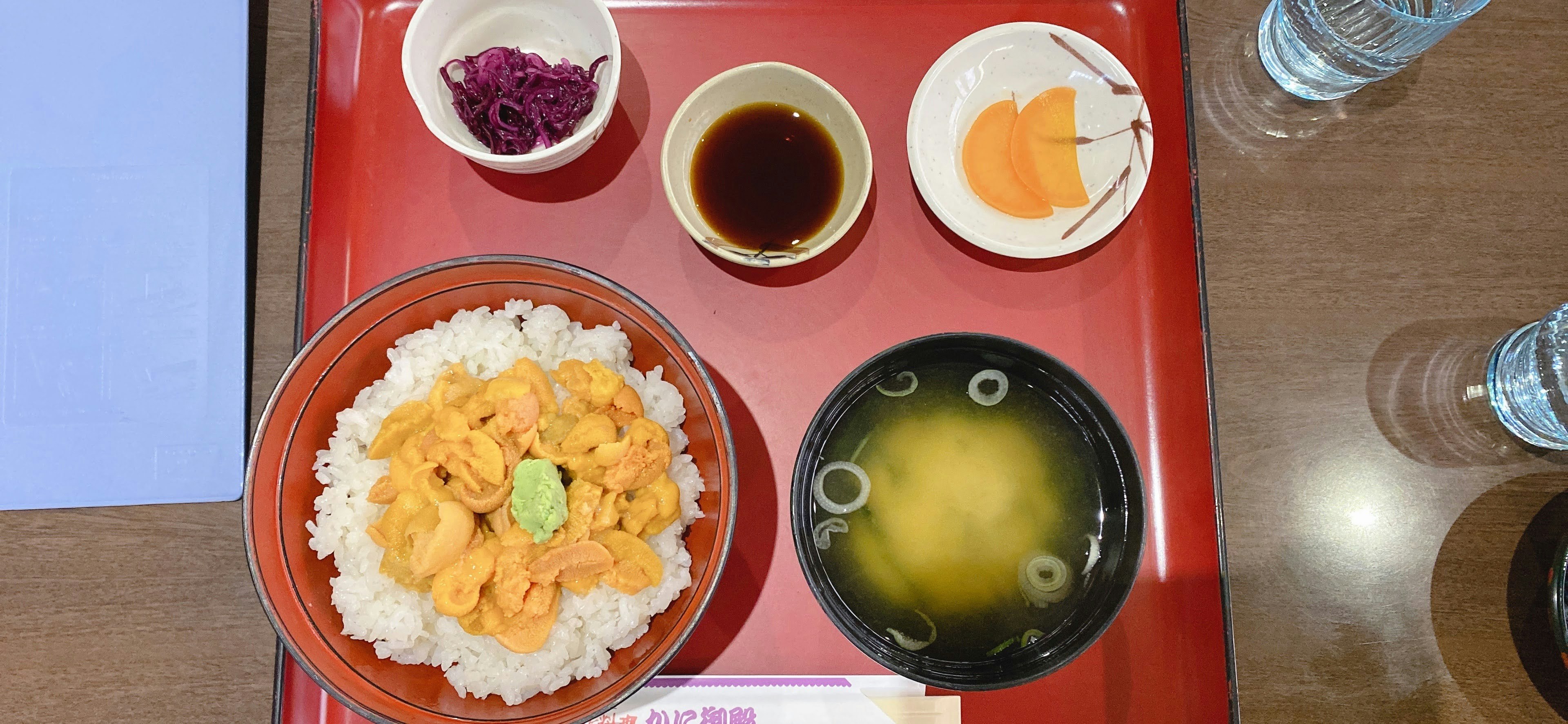 红色托盘上的日式定食：米饭、味噌汤和小菜