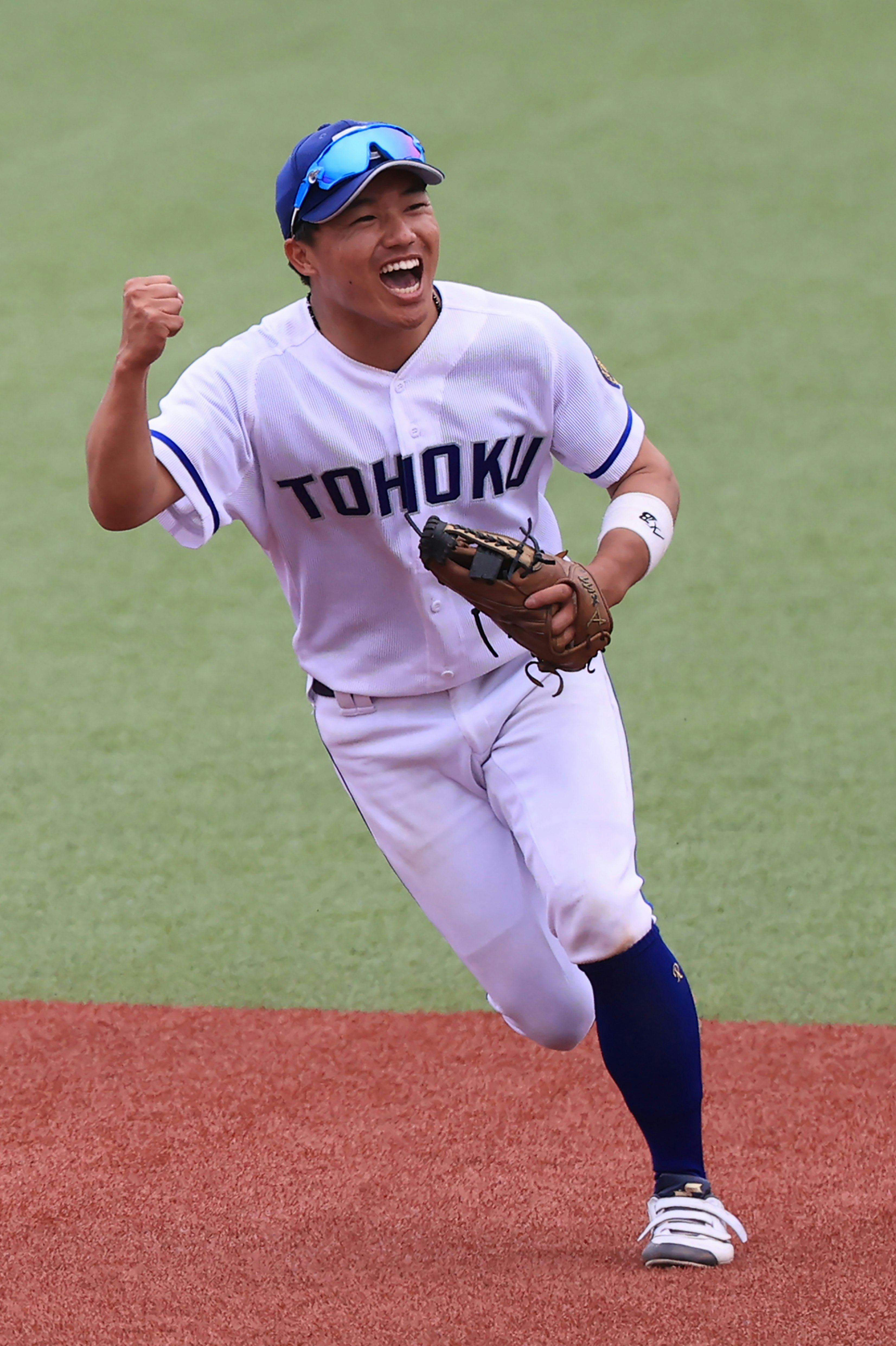 ユニフォーム姿の野球選手がグラウンドで喜びの表情