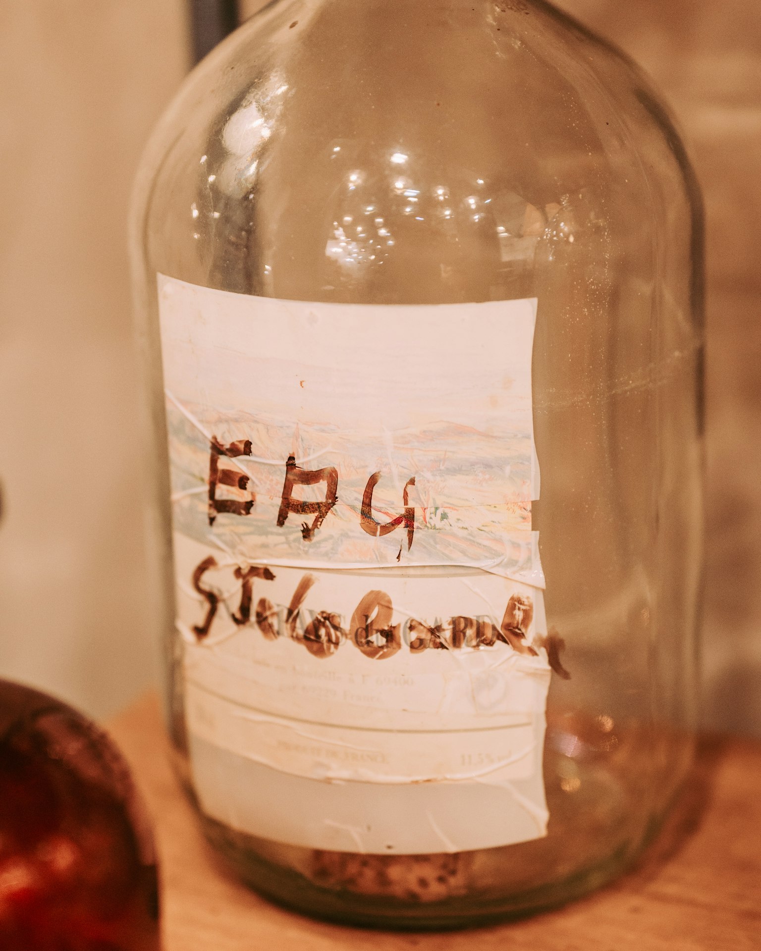ขวดเก่าที่มีป้ายเขียนด้วยมือ EAU ST.GILLES