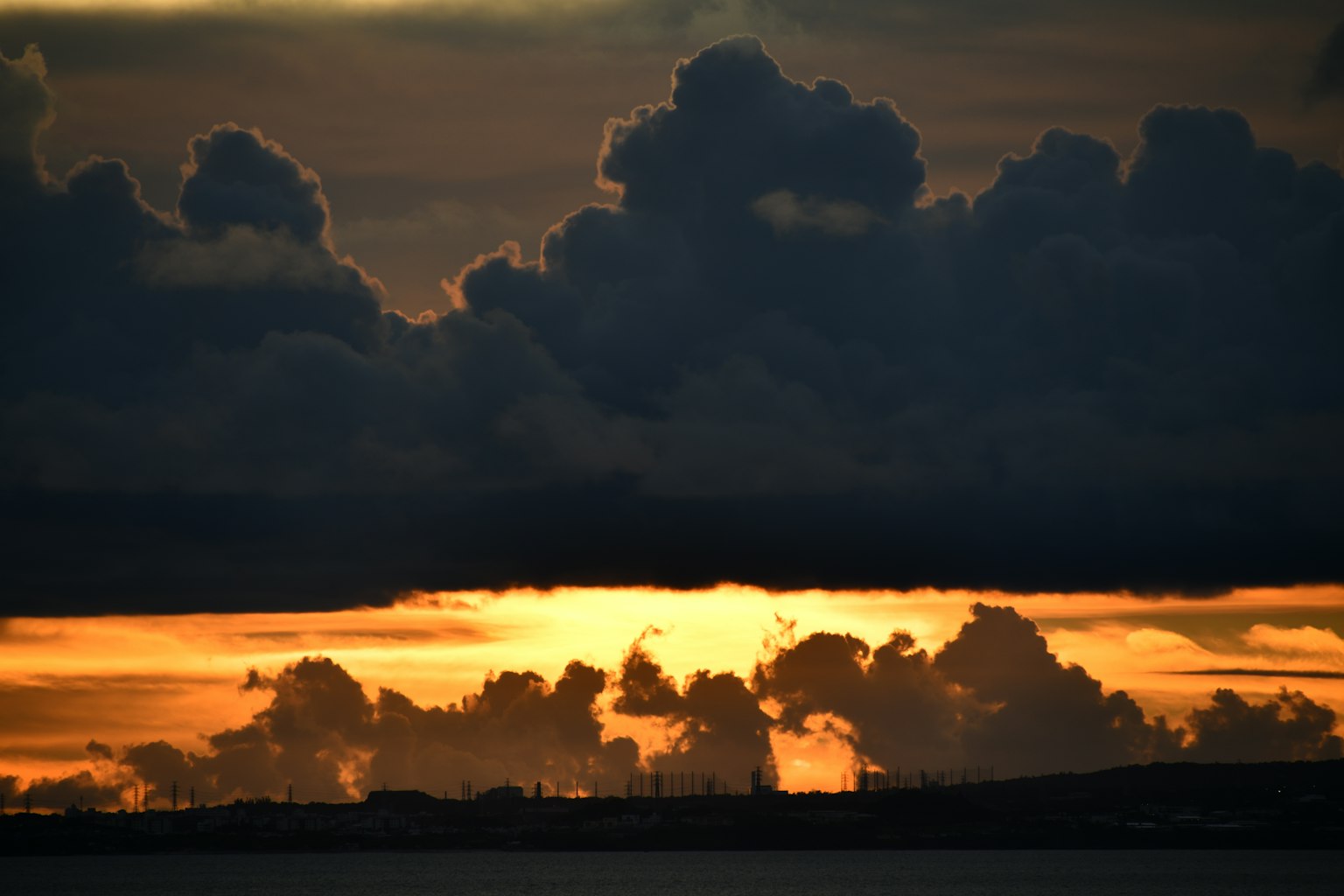 夕陽光輝照亮地平線上的暗雲