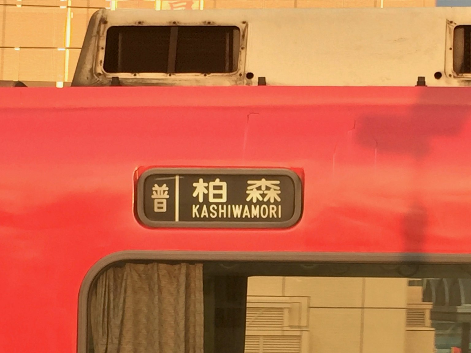 Schild an der Seite eines roten Zuges mit der Aufschrift Kashiwamori
