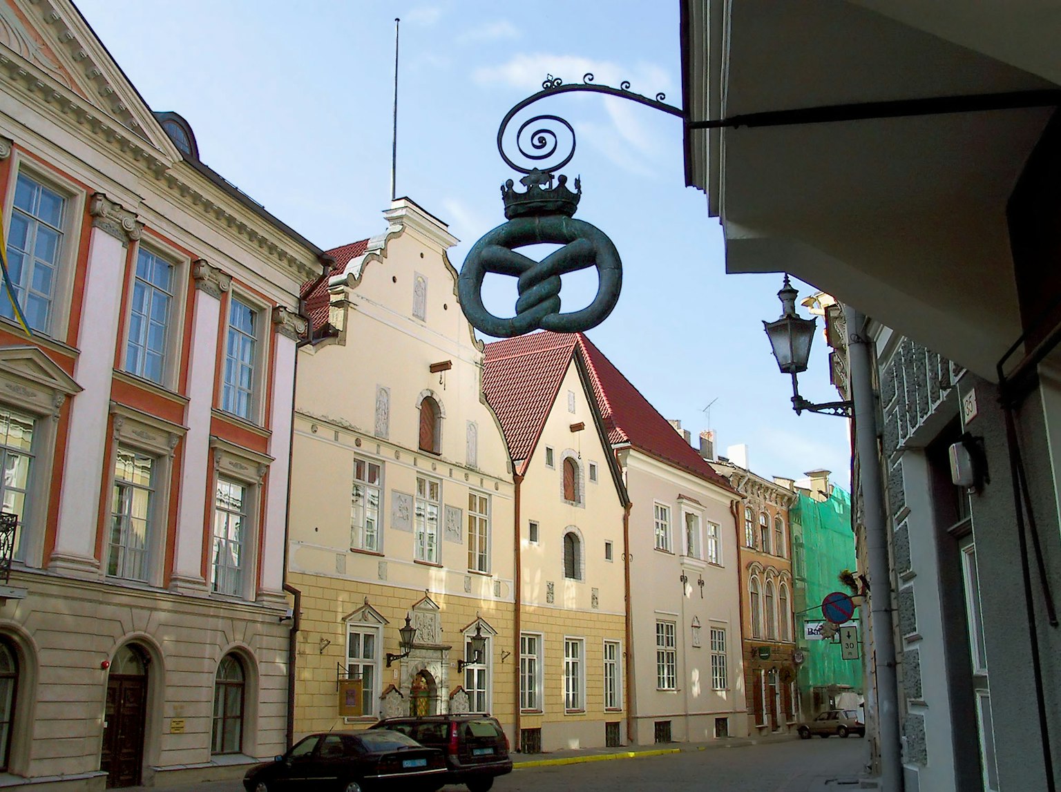Street view of Tallinn's Old Town featuring colorful buildings and decorative sign