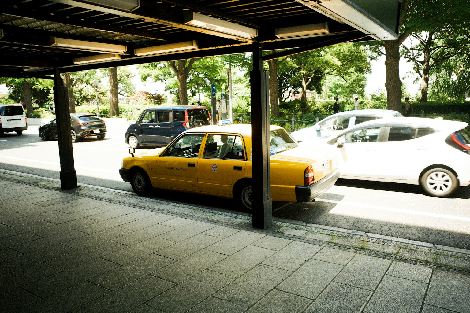 Una vista di un taxi giallo parcheggiato su una strada pavimentata accanto ad altri veicoli