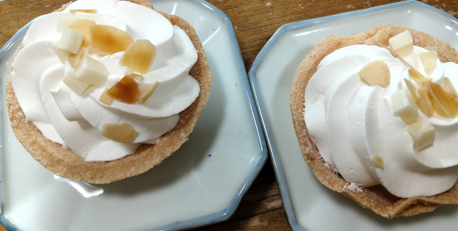 Zwei Desserttassen mit Sahne und Nüssen