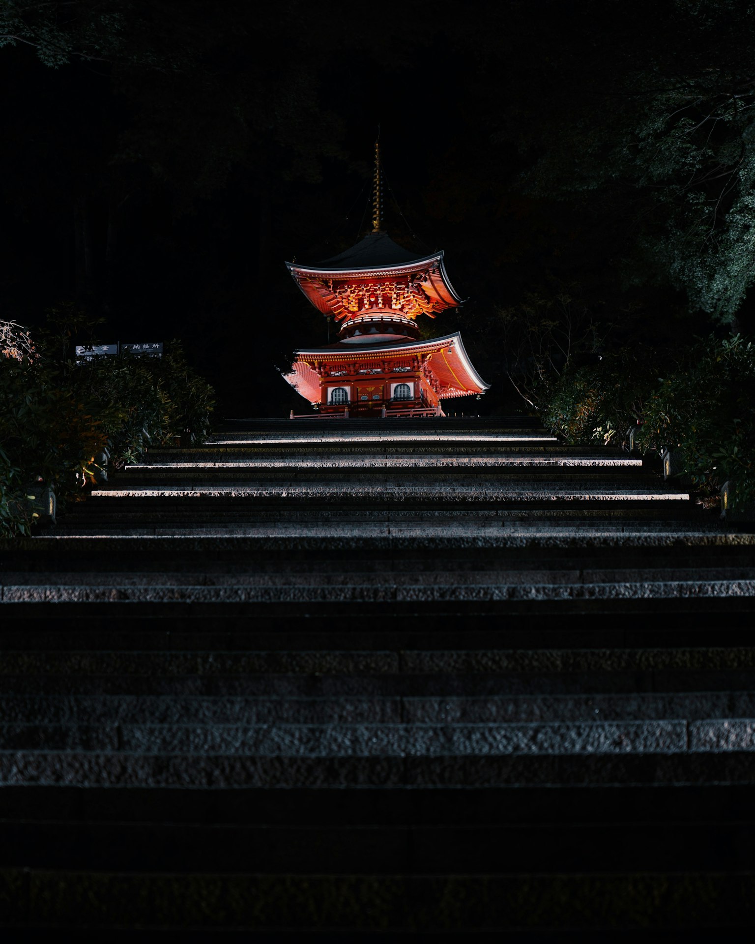 Illuminated red structure with stairs at night