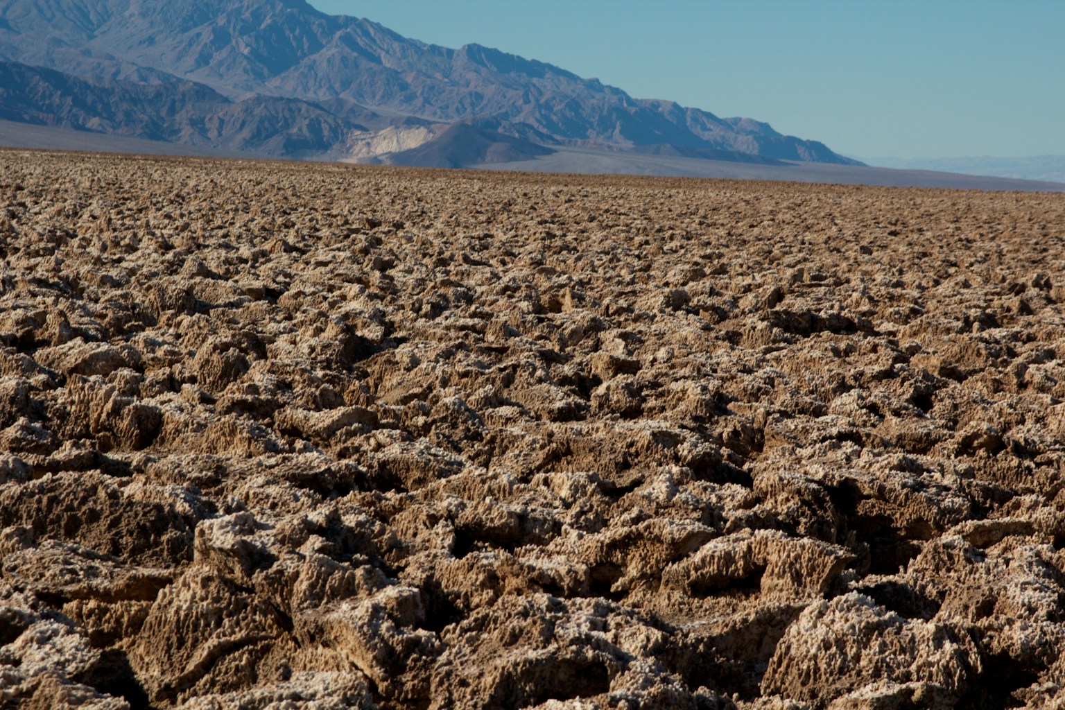 พื้นดินแห้งแตกและภูเขาในระยะไกล