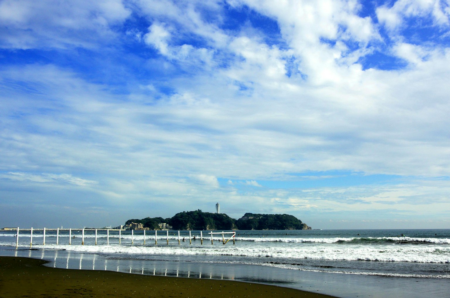 Coastal view with blue sky and white clouds over the ocean waves