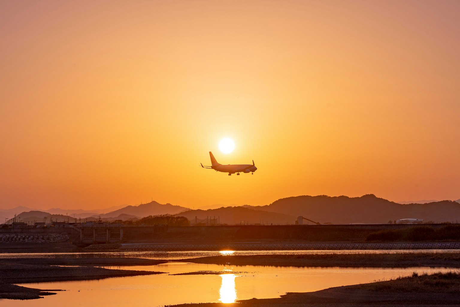 Flugzeug landet vor einem Sonnenuntergang