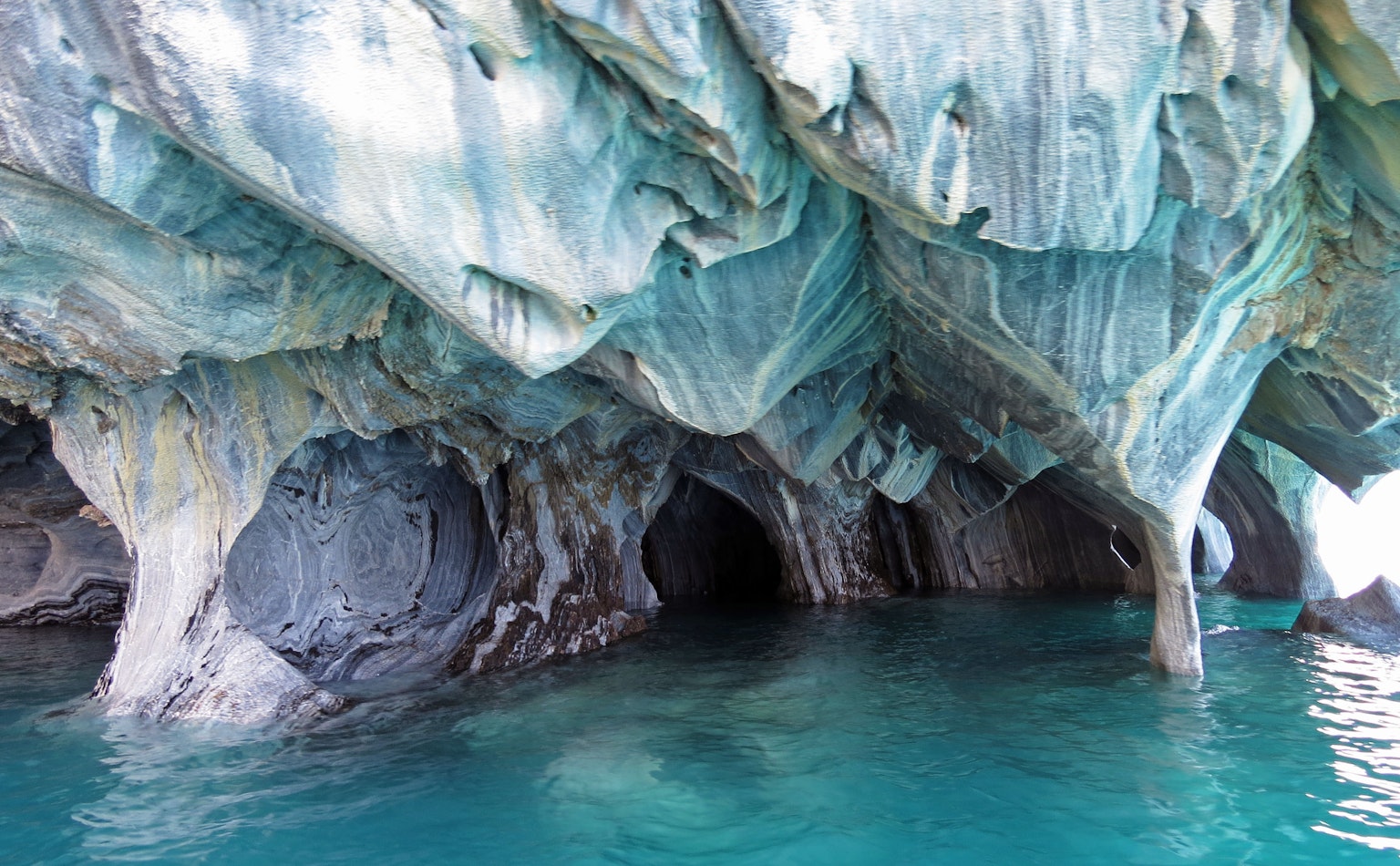 Intérieur des grottes de marbre entouré d'une belle eau bleue