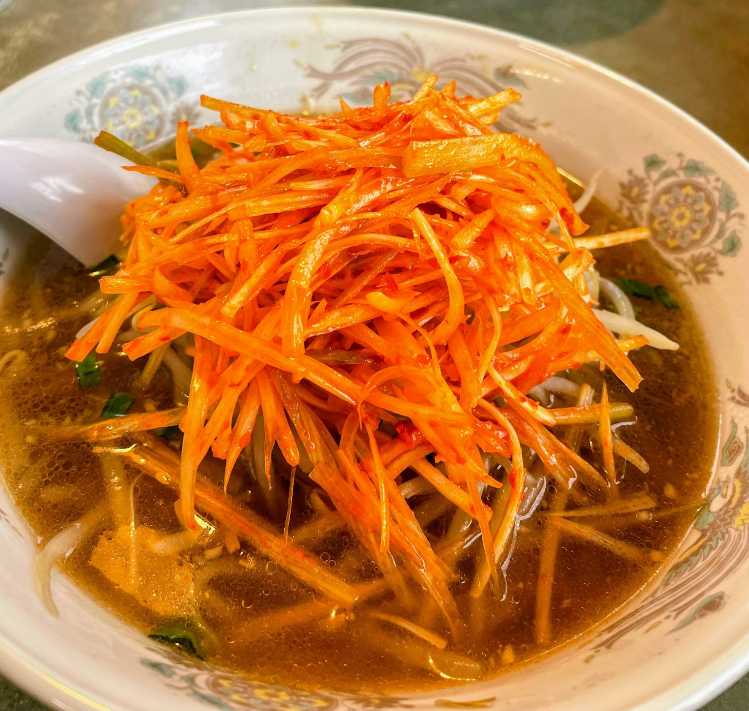 Tazón de sopa cubierto con zanahorias ralladas