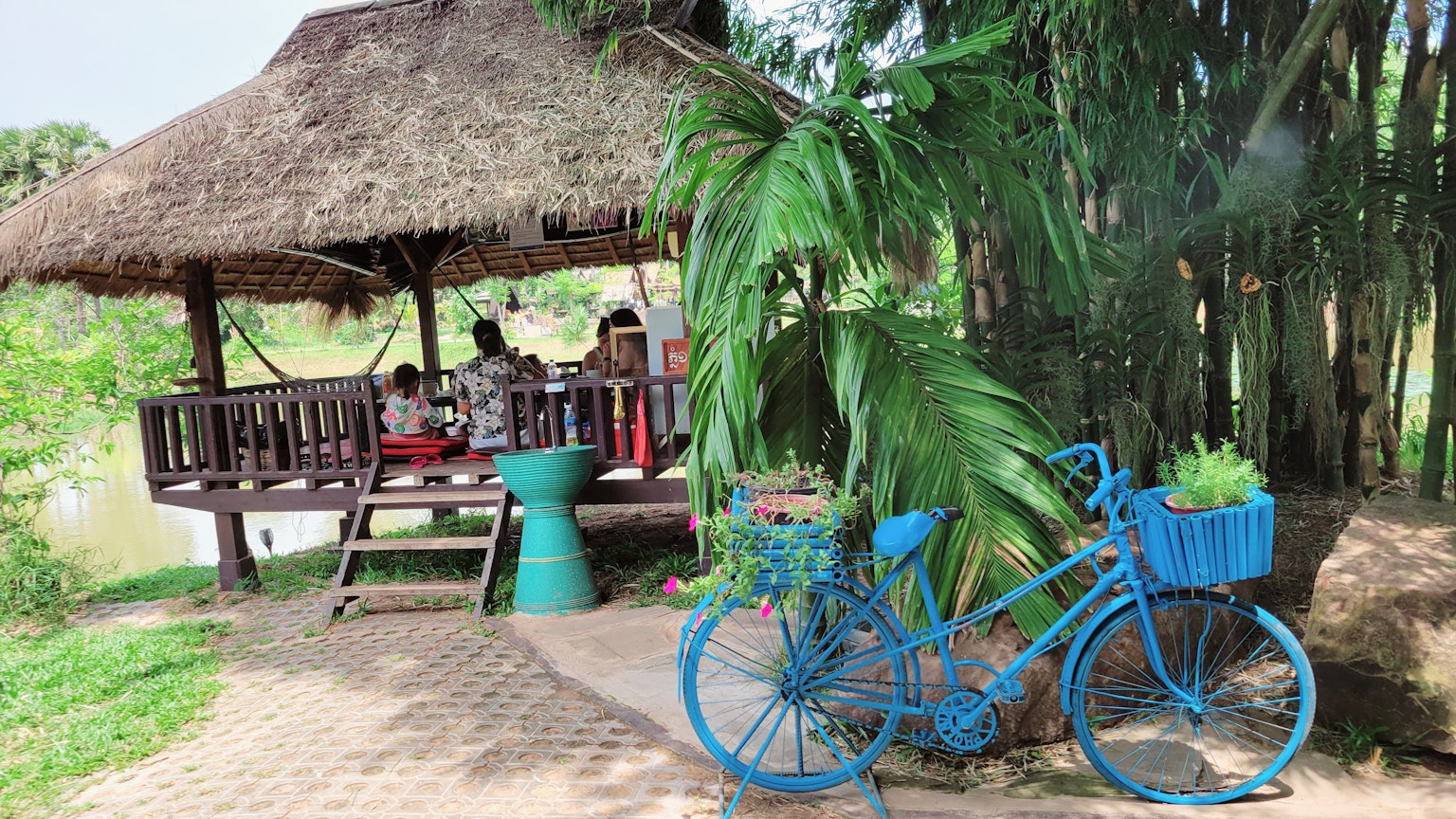 Escena rural con una bicicleta azul y un pabellón de paja