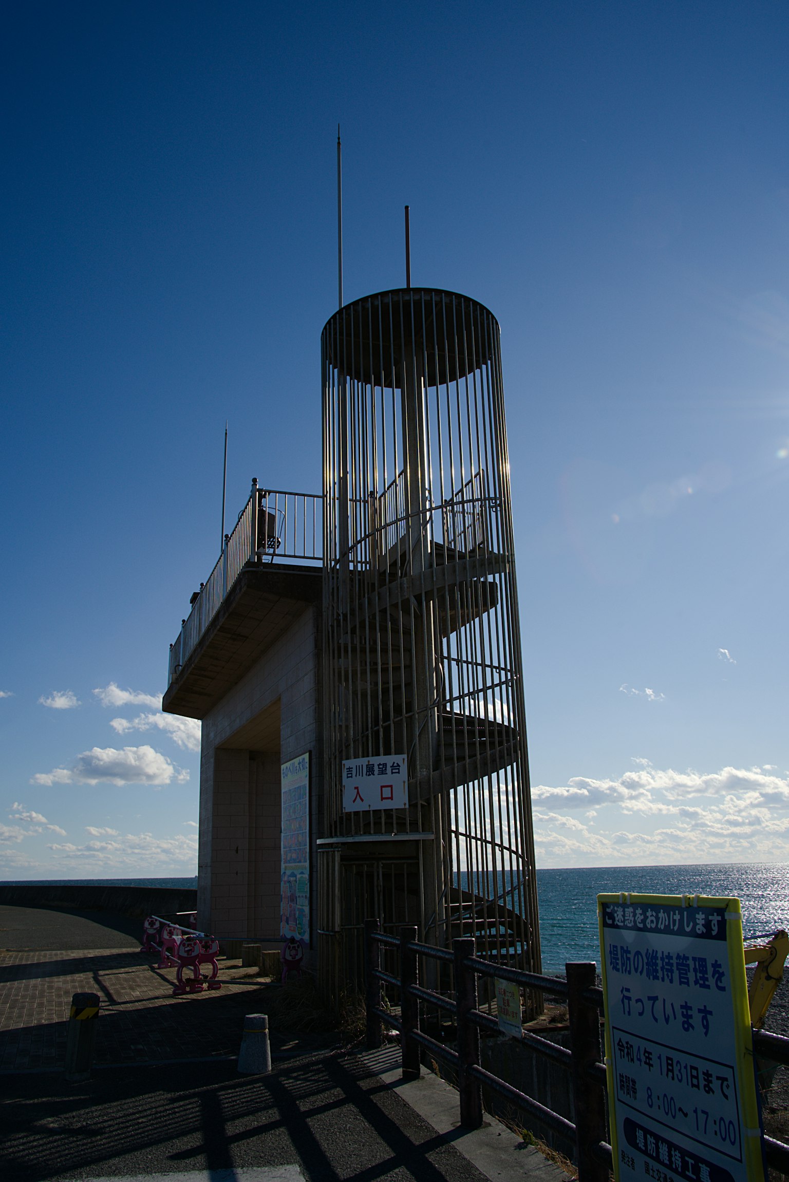 Torre de observación con escaleras en espiral junto al mar y cielo azul