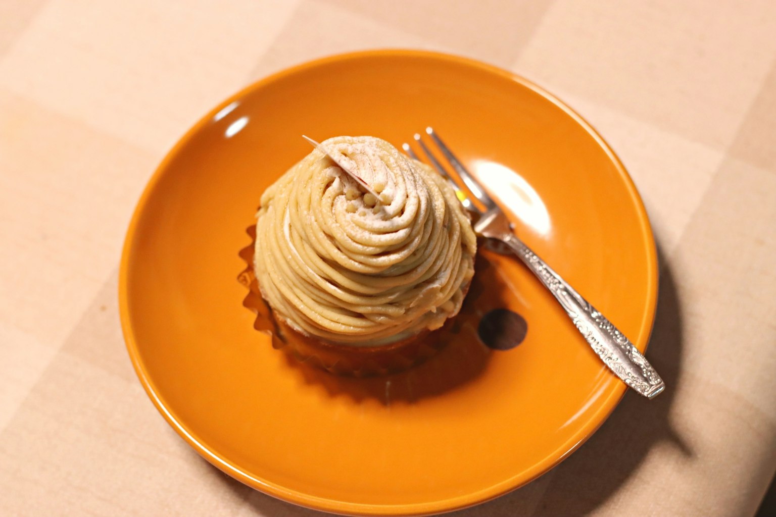 Gâteau Mont Blanc sur une assiette orange avec une fourchette