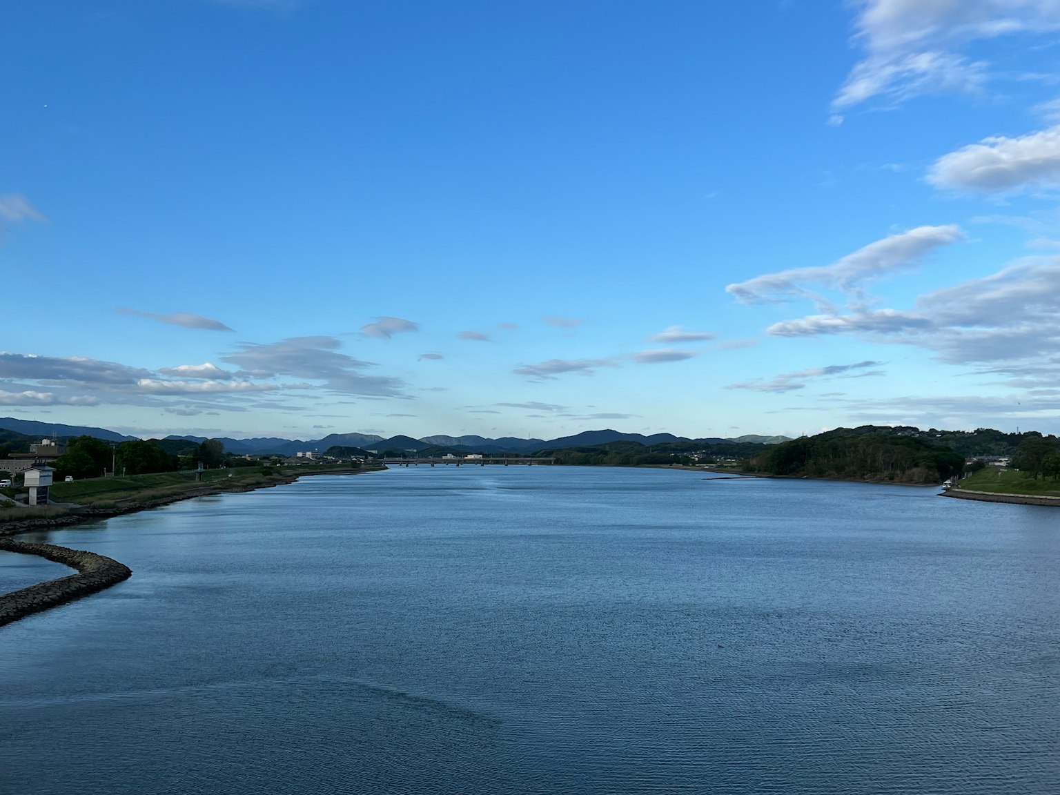 Un paisaje de río con un cielo azul y una superficie de agua tranquila