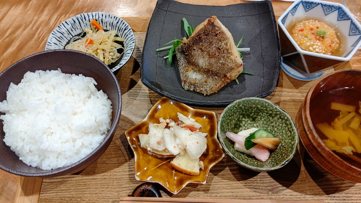 日式餐盘包含白米饭烤鱼和多样的配菜