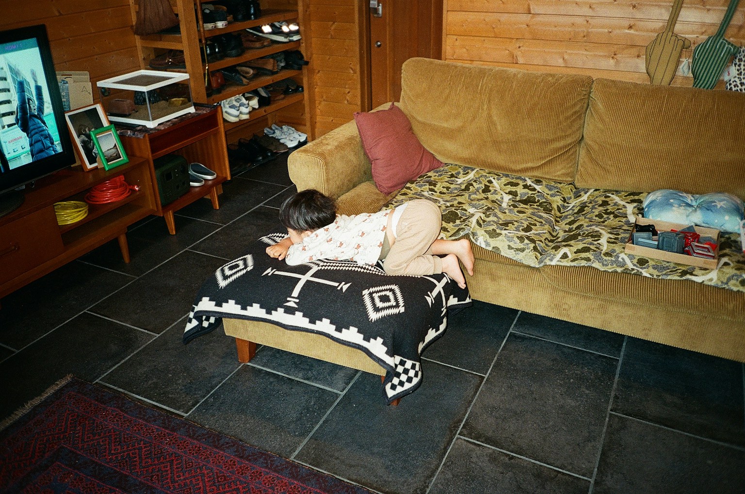 Kind spielt auf einem Sofa in einem gemütlichen Wohnzimmer