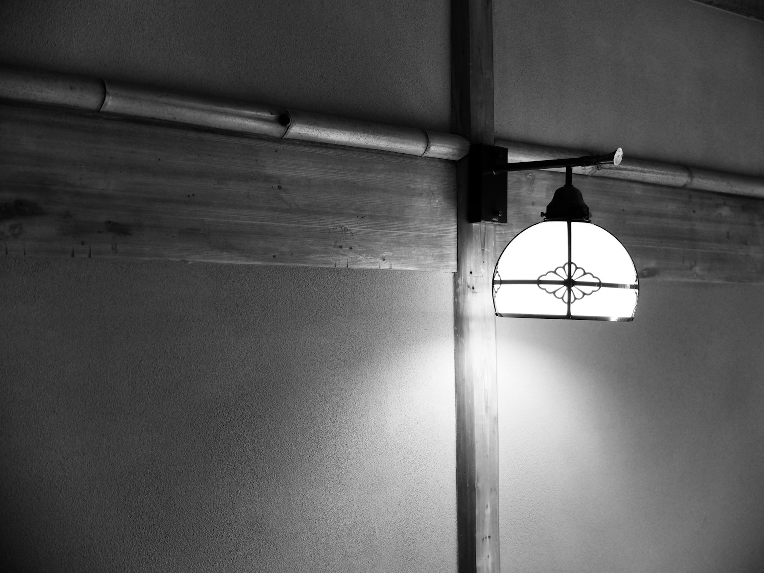 Une lampe rétro montée sur un mur noir et blanc mettant en valeur un éclairage unique