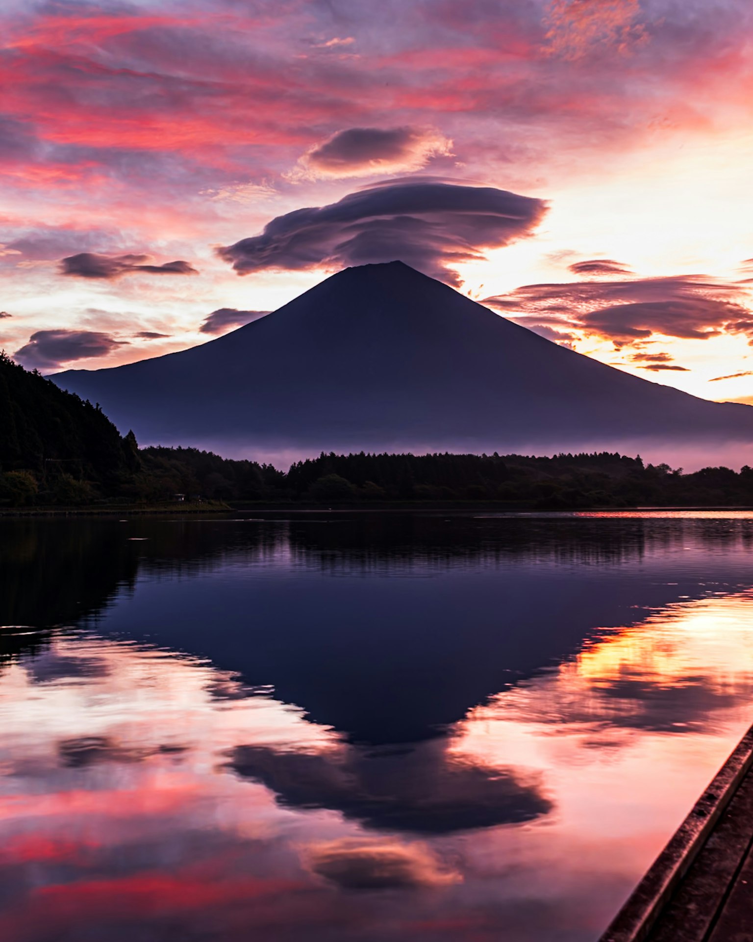 Gunung Fuji saat matahari terbenam dengan warna-warna cerah yang terpantul di danau