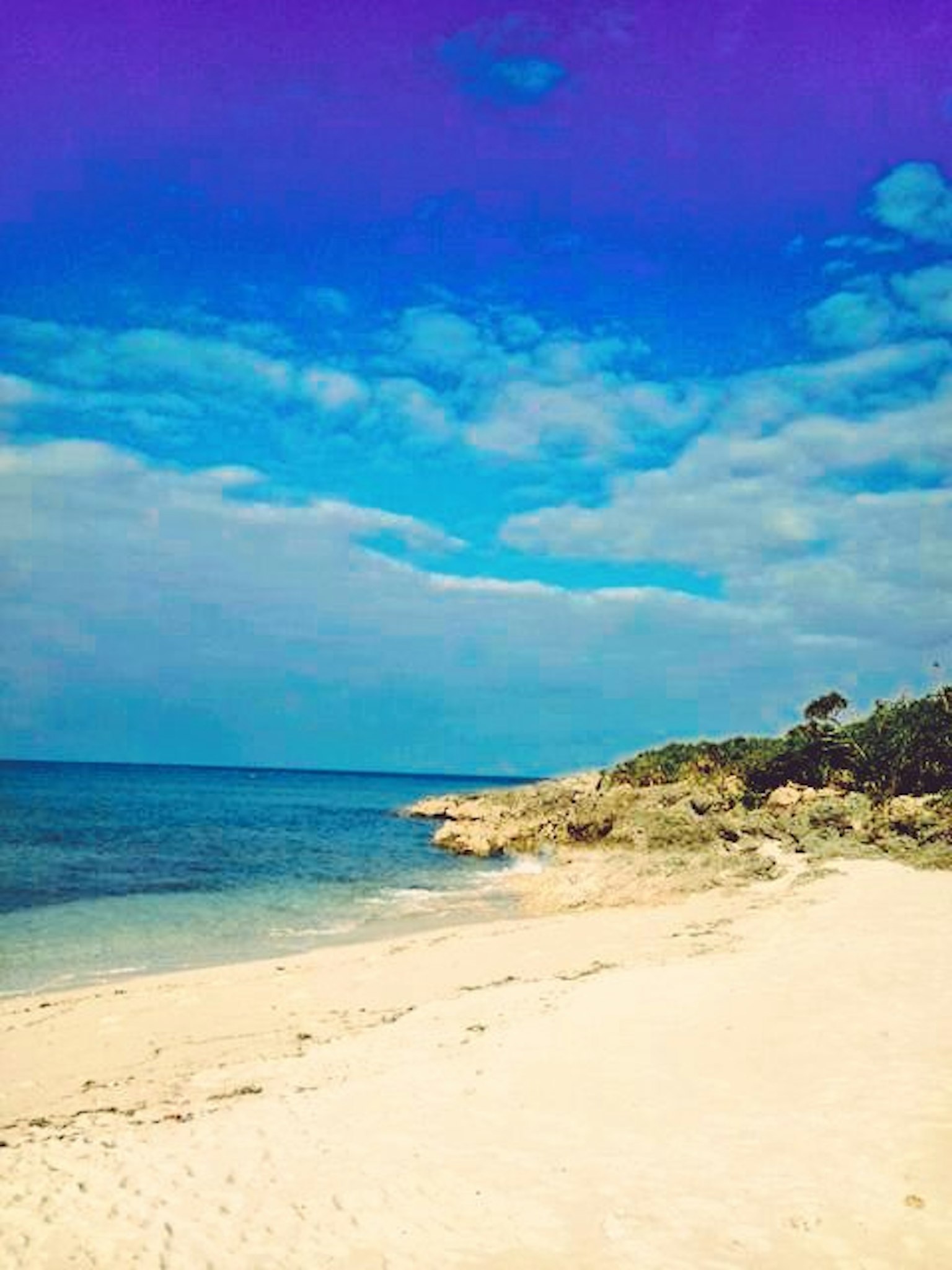 Beach landscape with blue sky and white sandy shore