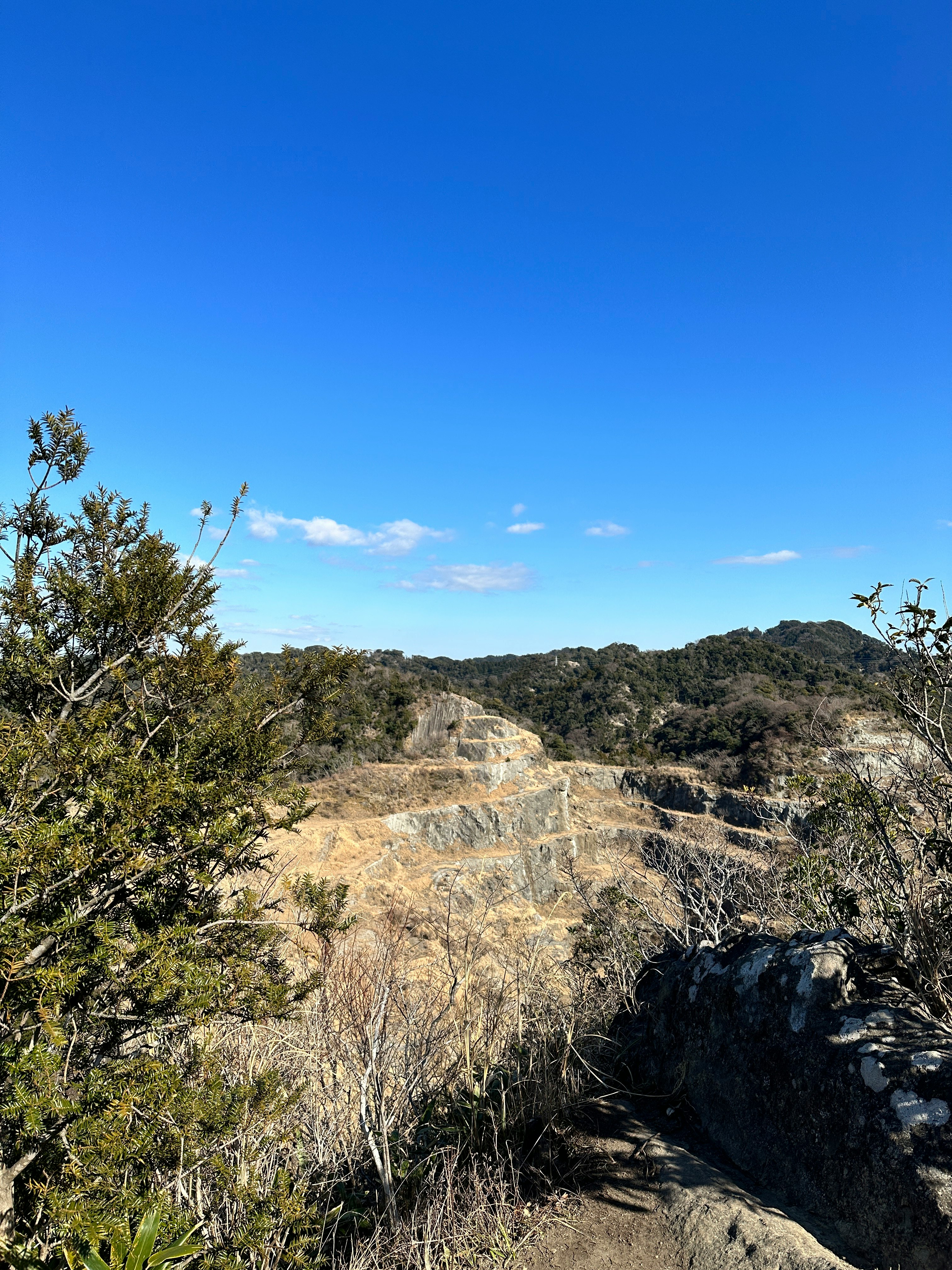 blue sky over a rocky mountain ridge with dry shrubs
