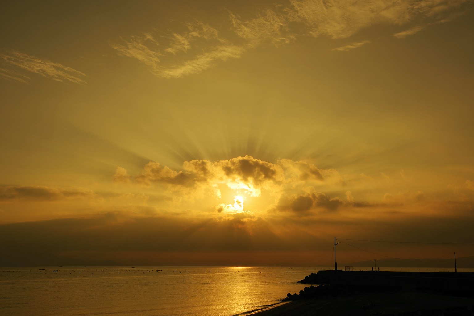 Tramonto dorato sul mare con nuvole e riflessi
