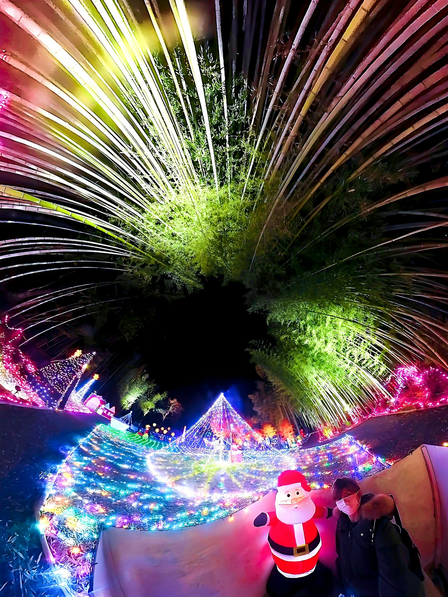 Colorful Christmas lights surrounding a Santa figure with a magical background
