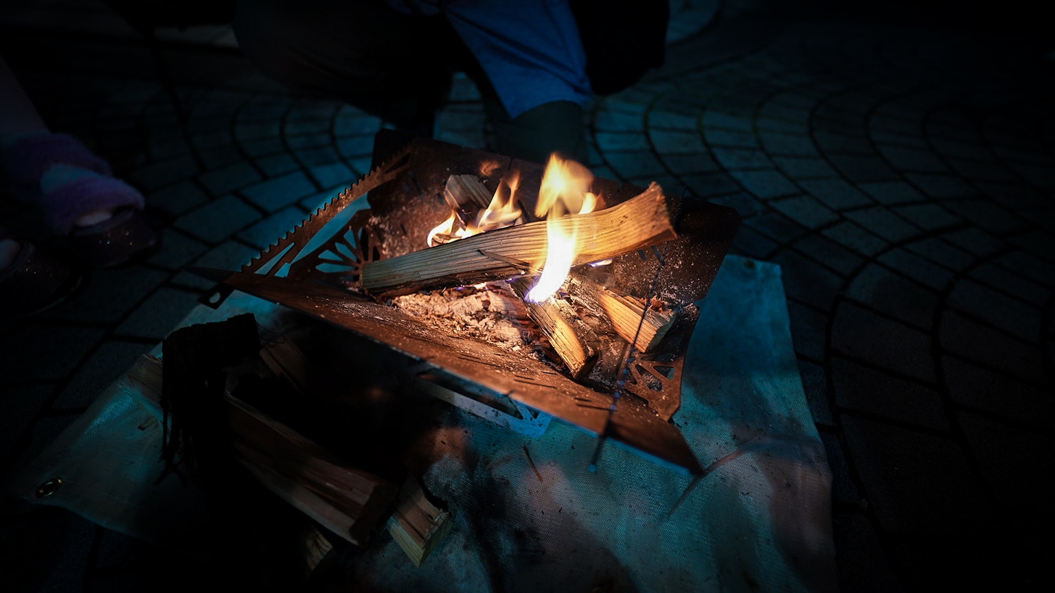 Un feu de camp chaleureux avec des flammes et des bûches dans une ambiance sombre