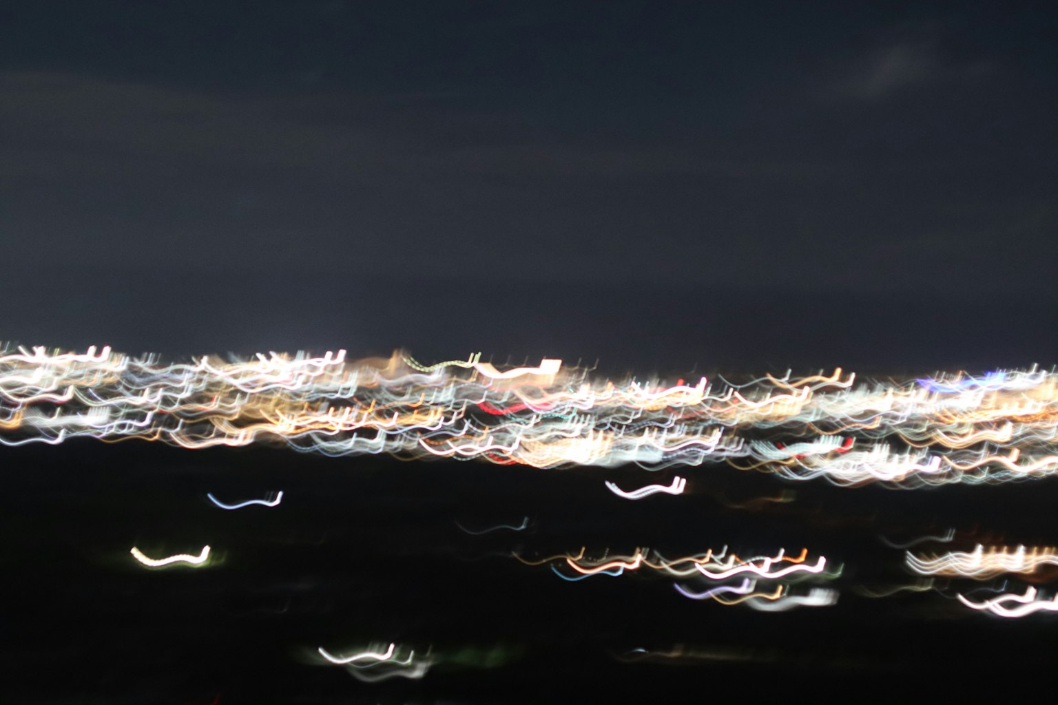 夜景のぼやけた光の点が広がる風景