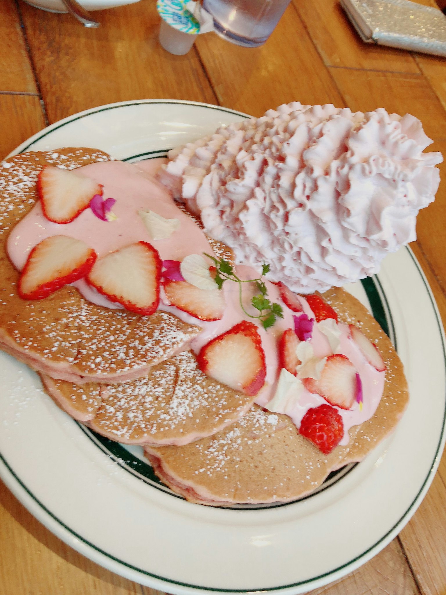 Assiette de pancakes garnie de crème à la fraise et de fraises fraîches