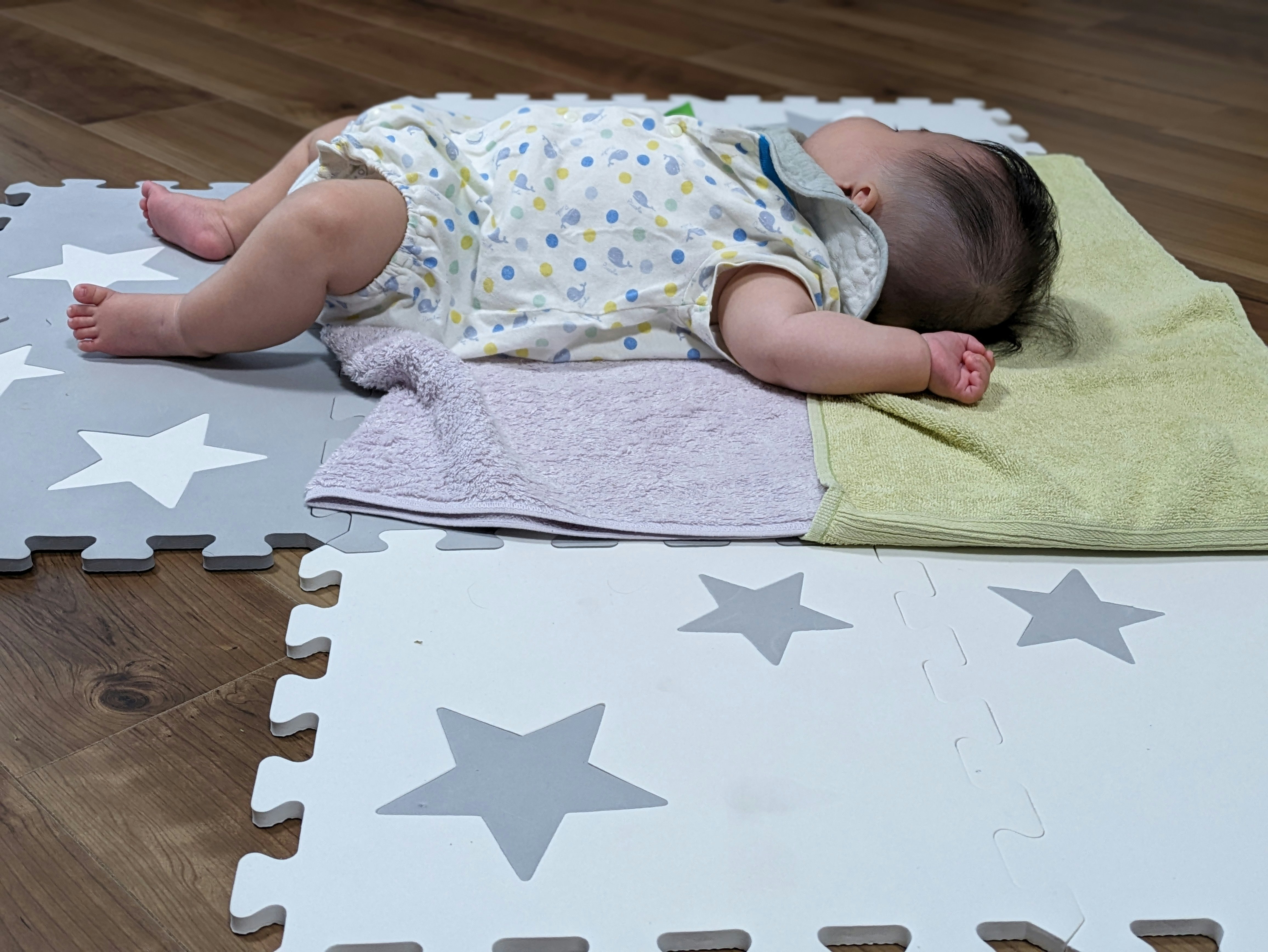 星形のパズルマットの上で眠る赤ちゃん
