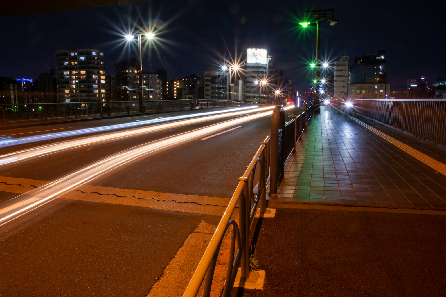 Vue nocturne d'un pont avec des lumières de voiture et des lampadaires lumineux